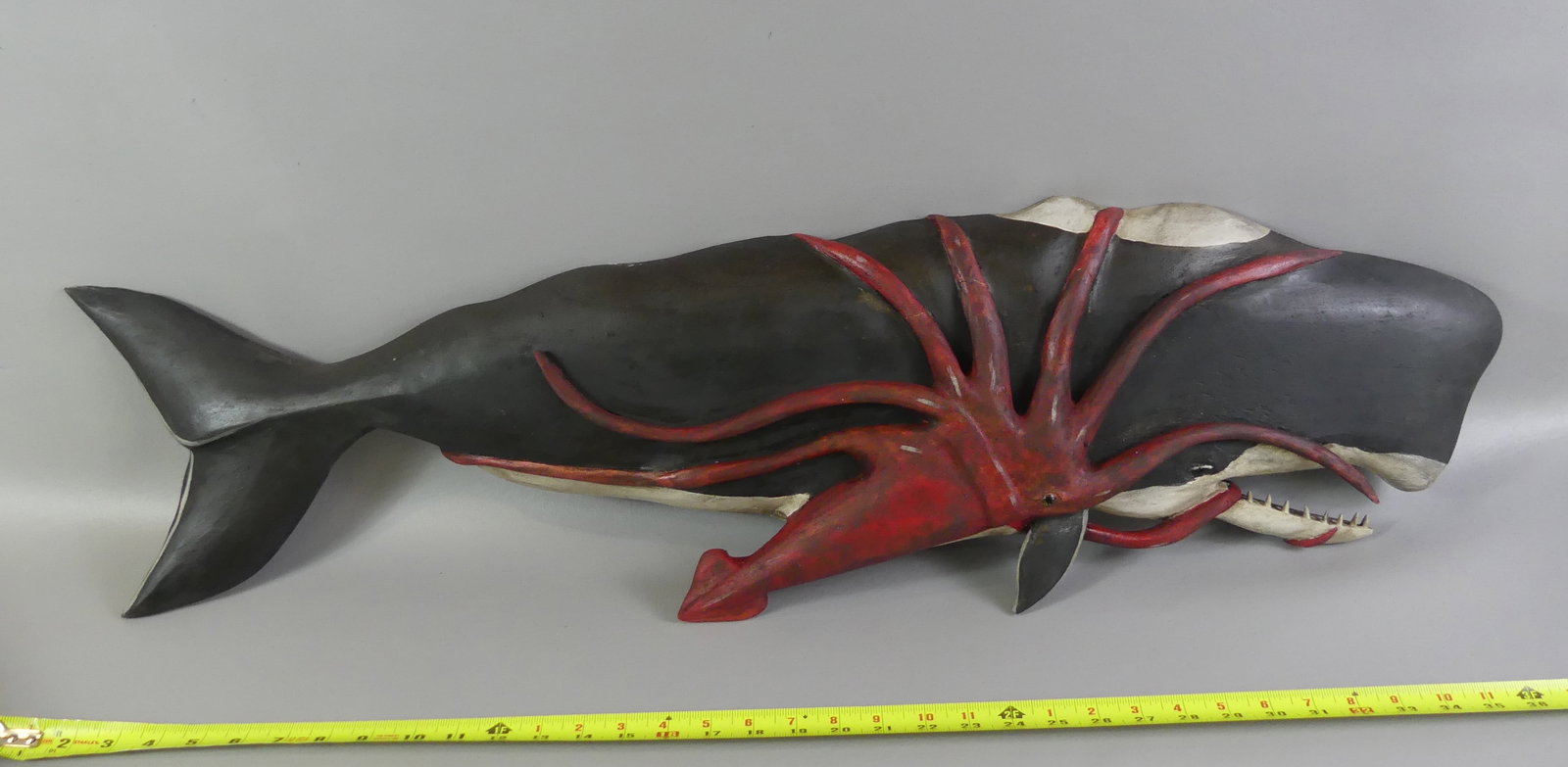 KEN BECKENHAUPT PLAQUE - KRAKEN ATTACKING WHALE: Large hand carved wood wall plaque depicting a giant squid (known by the sailors as a Kraken) attacking a sperm whale, signed Ken Beckenhaupt Cape Cod. 39 x 11 inches. Excellent condition.