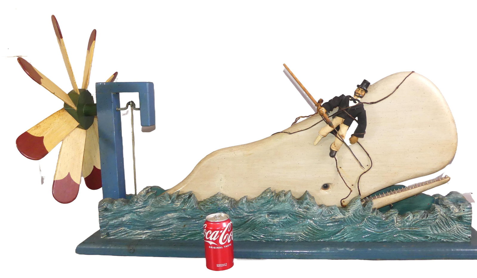 LARGE SAILOR & WHALE WOOD WHIRLIGIG: Large vintage carved and painted wood whirligig depicting a peg-leg sailor with harpoon flailing against a huge whale. 40 in long x 24 h x 6.5 in deep. When the paddle wheel spins the whale's mouth mo