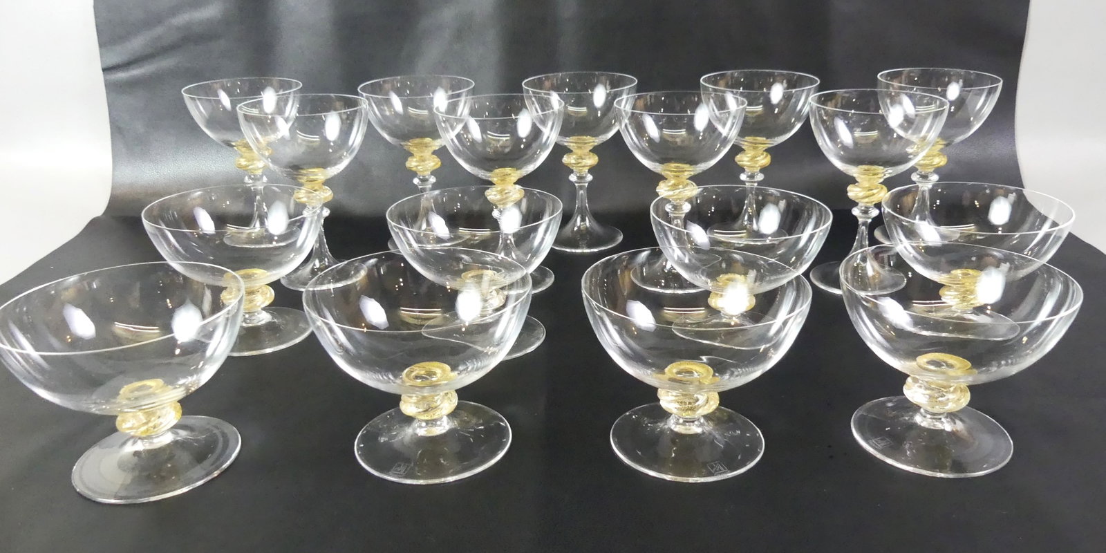 17 PIECES OF VENETIAN STEMWARE: Lot of 17 pieces of hand blown Venetian glass including 9 champagne or wine glasses (4 x 5.75 in) and 8 sherbet or coupe glasses (4.5 x 3.75 in high). Each has a knopf with gold spatter. All excellent