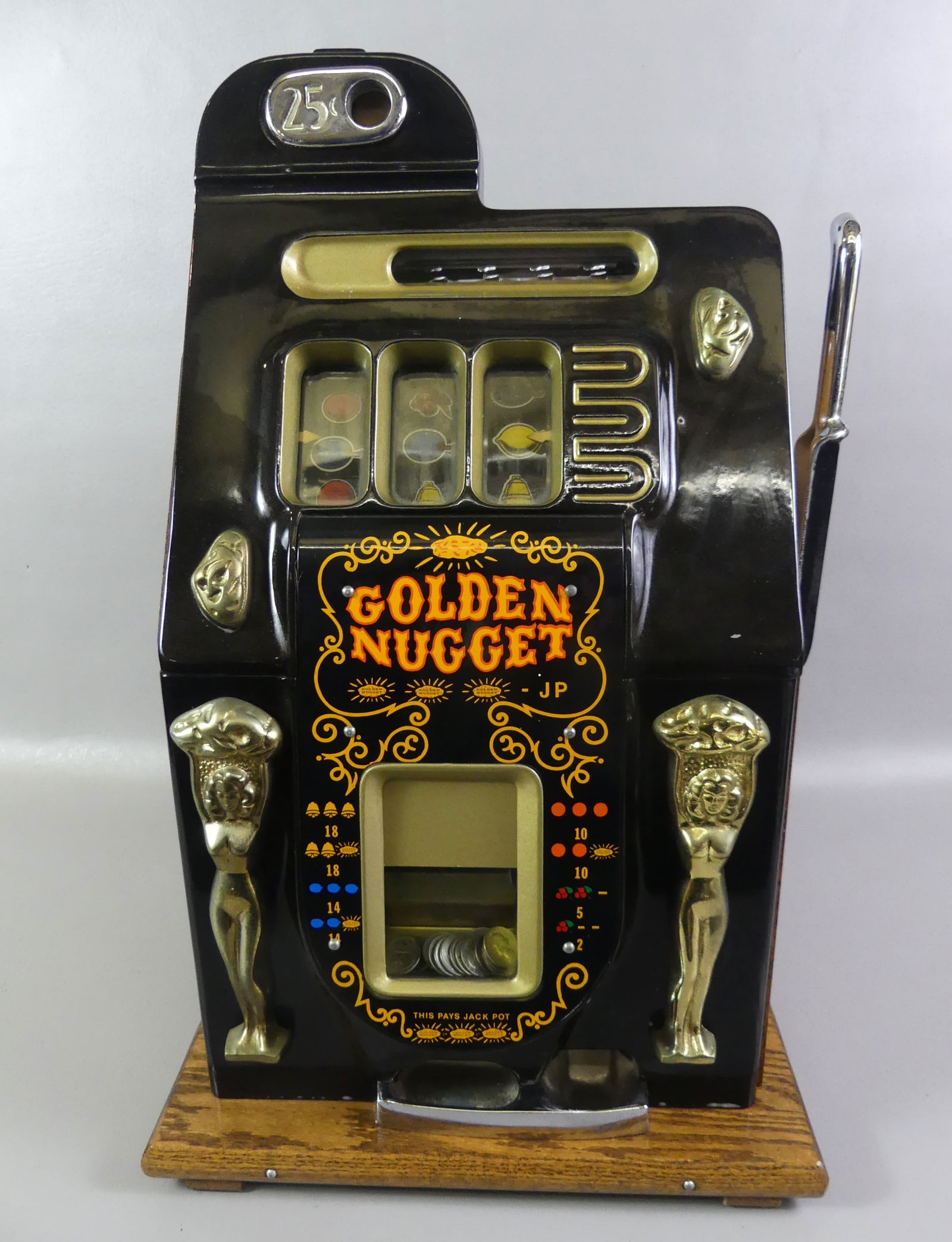 OLD 25C GOLDEN NUGGET SLOT MACHINE: Old Golden Nugget 25C slot machine in oak and metal case circa 1930's. Has applied brass nude women on front. Case is 26 in high x 15 x 15 in. Working.