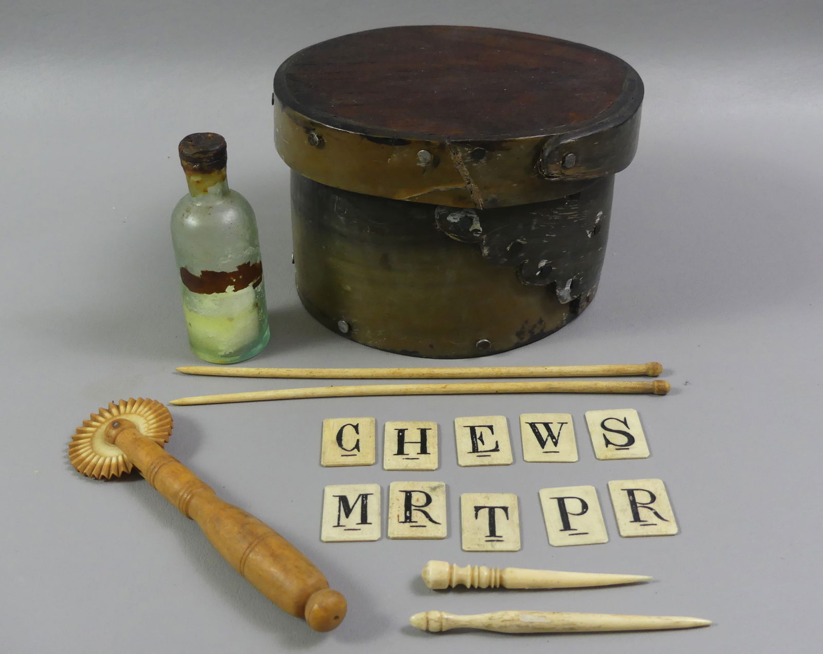 15 WHALING RELATED ITEMS: Lot includes: 6 in crude whale baleen ditty box; 2 fids; set 8 bone tiles with letters; 2 needles; and glass sperm oil bottle. About 15 pieces.