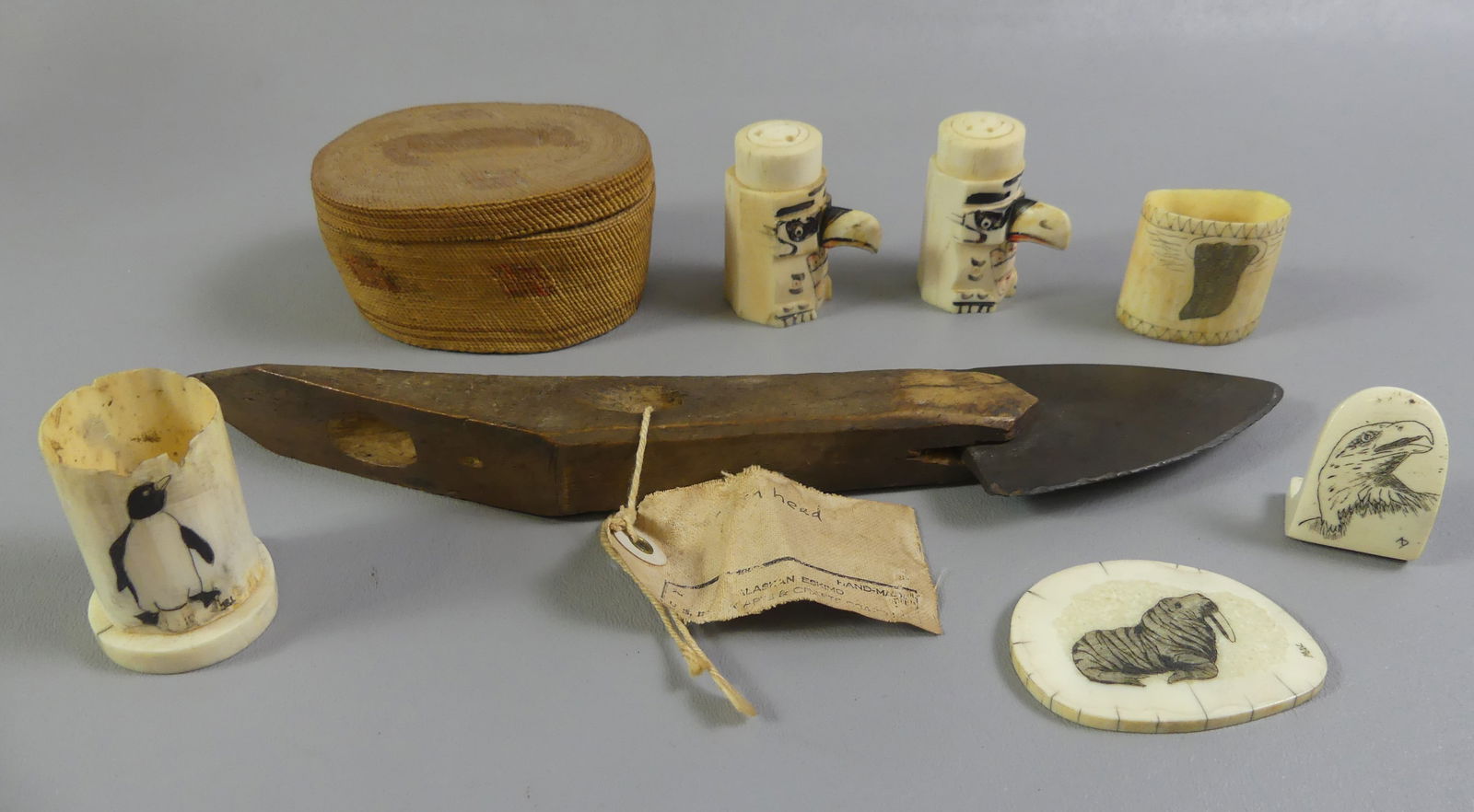 8 CARVED INUIT ITEMS: Lot of 8 mostly Inuit carved whale bone items: early hand crafted bone dagger with stone blade, old Alaskan Eskimo tag; 3.5 in fine woven basket or mini box; pair salt and pepper shakers; and 4 scrims