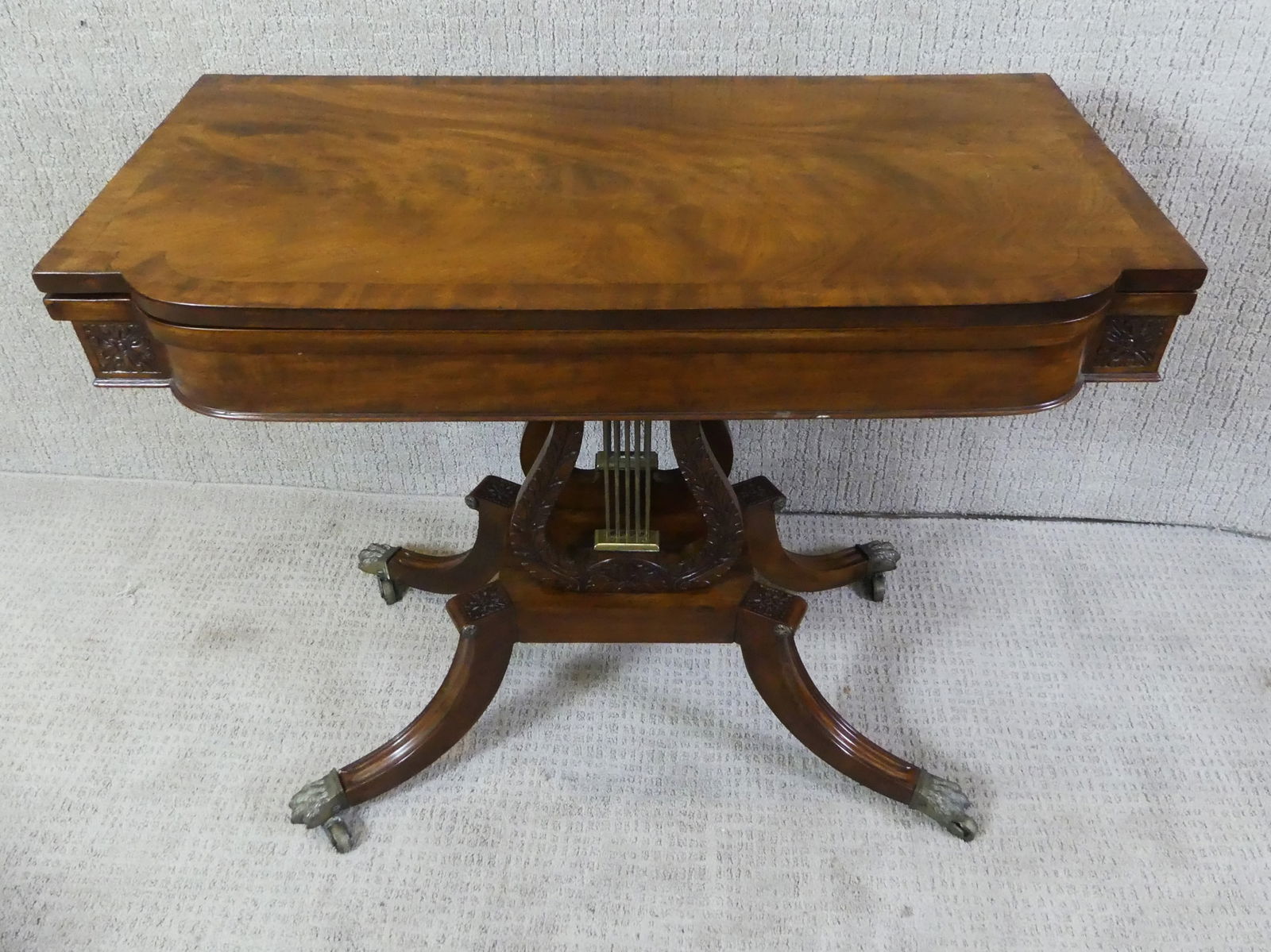 FEDERAL MAHOGANY LYRE BASE CARD TABLE: Early 19th century mahogany Federal Duncan Phyfe carved card table with lyre base and brass paw feet. 35 in w x 29 h x 17.5 in deep. VG condition.