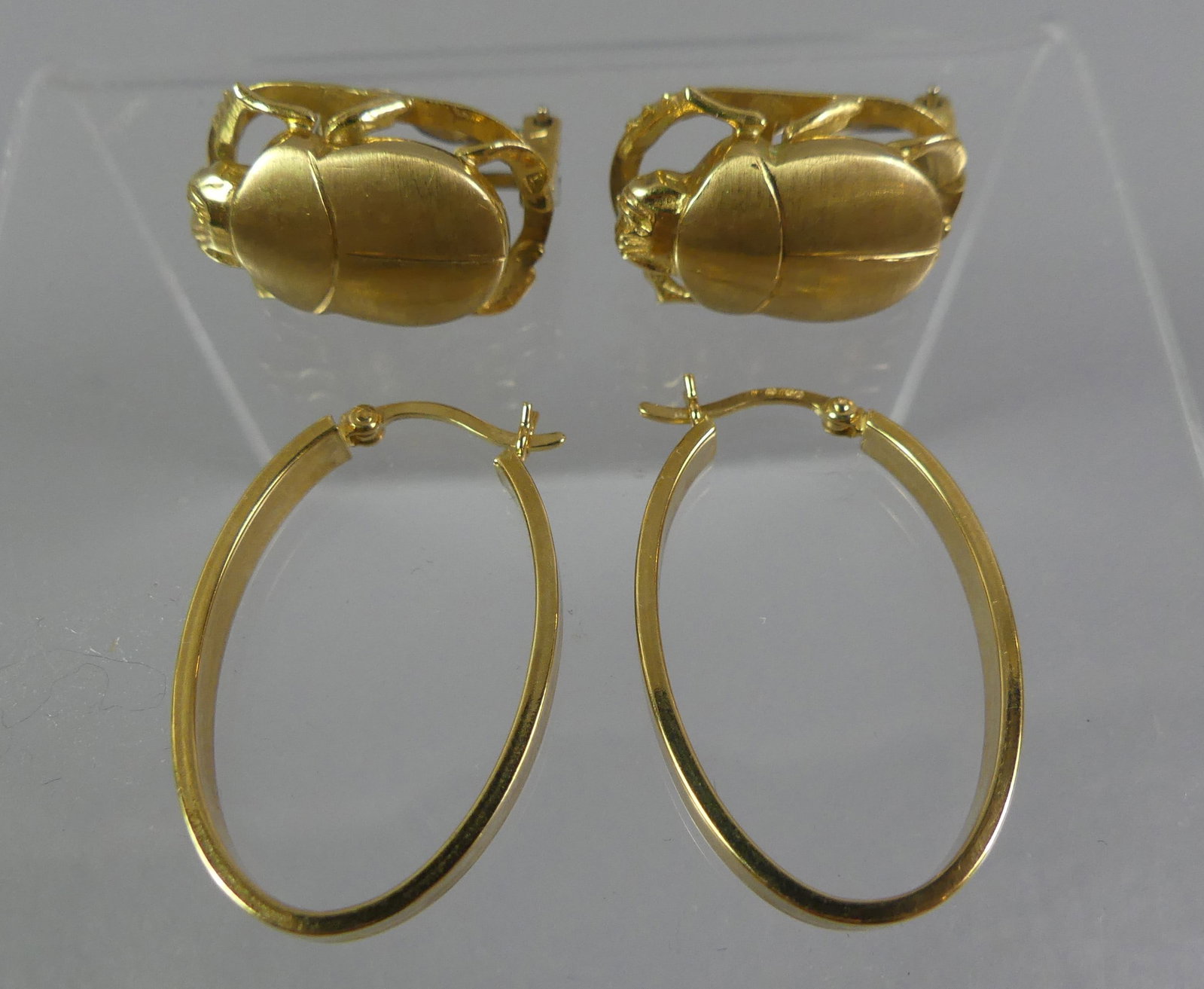 TWO PAIRS 18K GOLD EARRINGS: 2 pairs of 18k gold earrings: one inch oval hoops and pair of scarab (beetle) earrings signed Lalaounis (Greek jewelry firm). About one in long. Total 11 dwt.