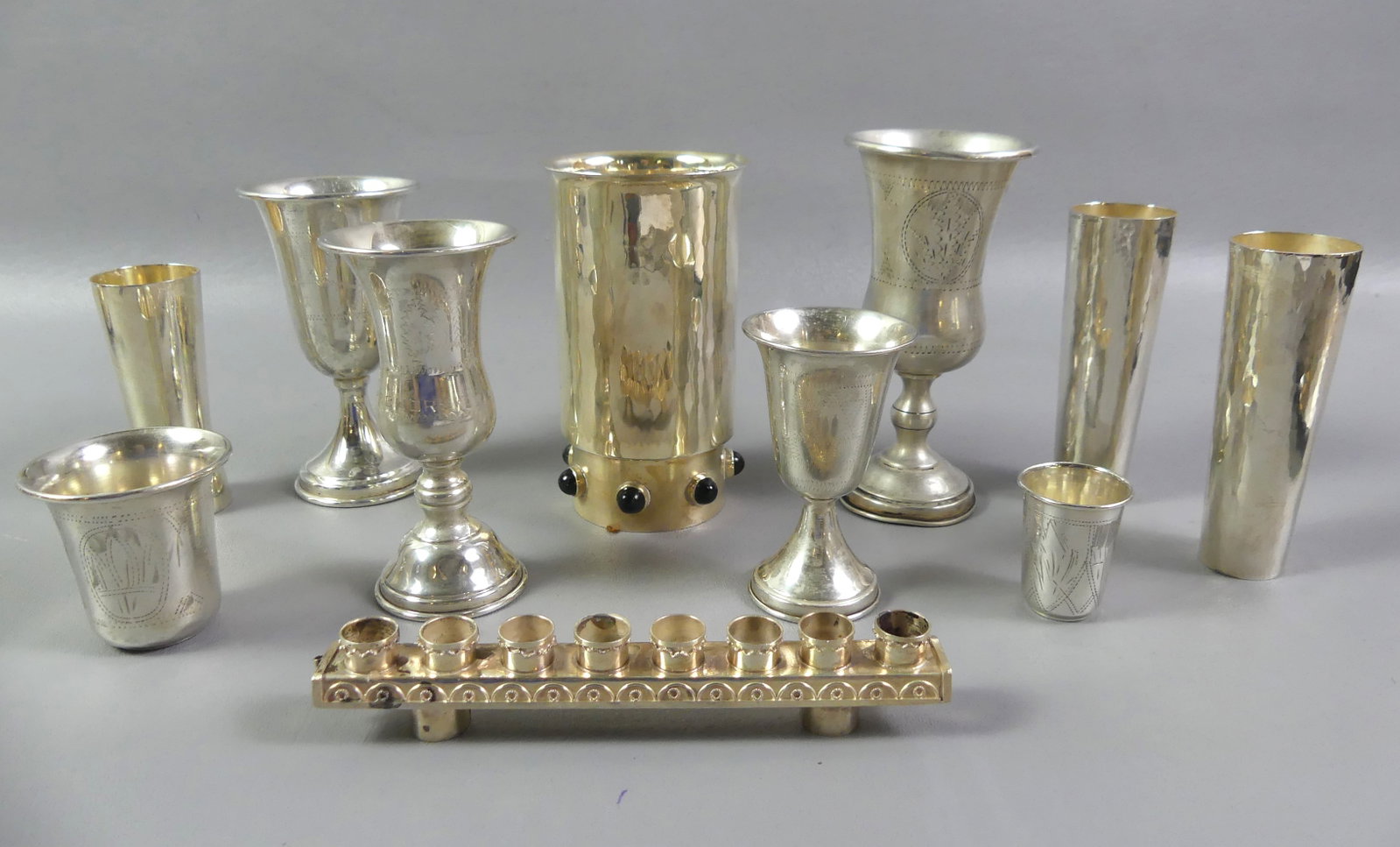 ISRAELI STERLING SILVER CUPS - SEGAL & BERMAN ETC: Lot of mostly Israeli silver items: Heavy jeweled and hand hammered sterling tumbler with dark green stones signed TAS (Zelig Segal & Menachem Berman) Israel (9.5 ozt); 9 cups and shot cups to 5 in ta