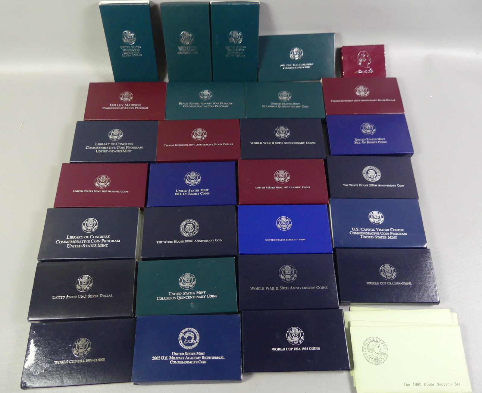 28 BOXES SILVER COMMEMORATIVE COINS: Large lot of 28 boxes of US silver commemorative coins including three 1980 one dollar souvenir sets; many silver dollars etc.
