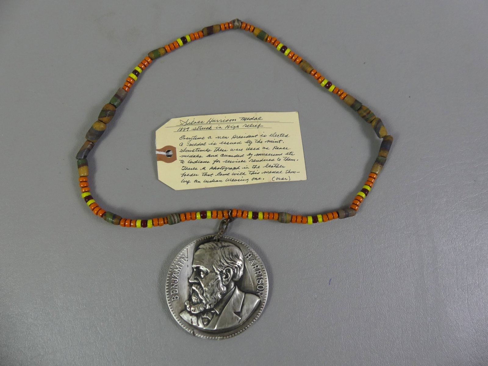 HARRISON PRESIDENTIAL PEACE MEDAL: Silver presidential inauguration or peace medal for President Benjamin Harrison dated 1889, mounted on 24 in trade bead necklace. Medal is 3 in diameter. Has wear/scratches and thread-like oxidation? 