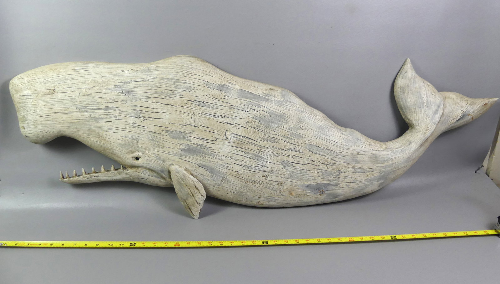 BECKENHAUPT LARGE WHALE PLAQUE: Large sperm whale painted wood plaque with glass eye and teeth signed Ken Beckenhaupt Cape Cod. 50 x 17 in high. Distressed white paint.