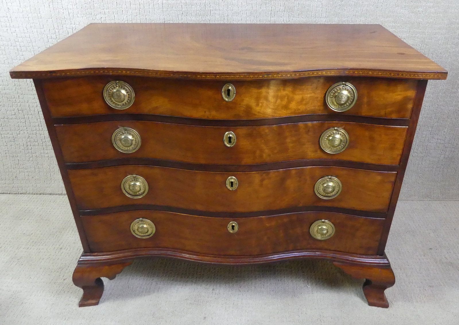 PERIOD BOSTON CHIPPENDALE INLAID MAHOGANY CHEST: Period inlaid Boston Chippendale serpentine front 4 drawer chest in Santo Dominican mahogany with checkered band inlay, original ogee bracket feet, unusual round brasses with stars and stripes (appear