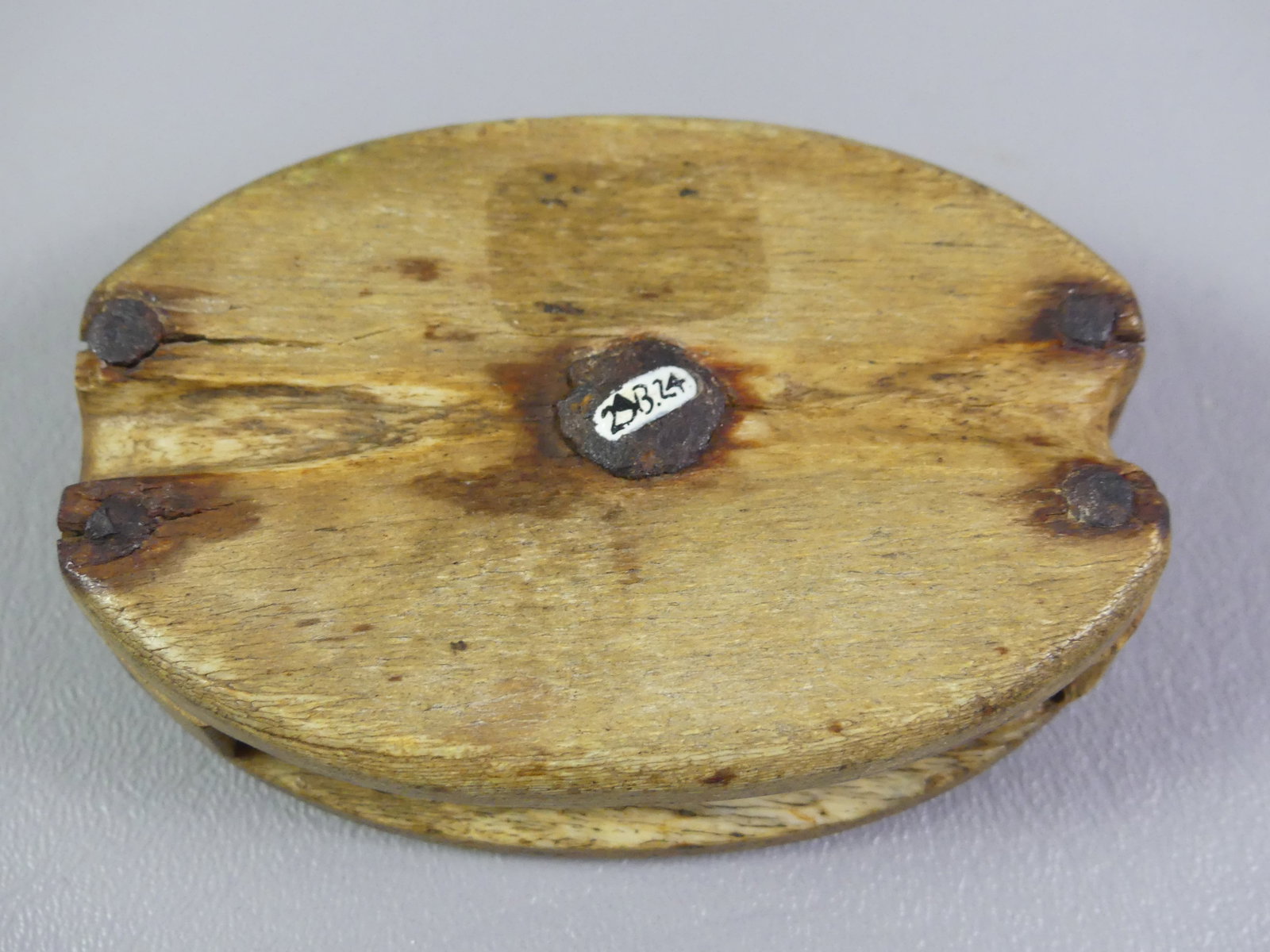 WHALE BONE PULLEY BLOCK: 19th century whale bone carved pulley block with old collection number on one side. 3.5 x 2.25 x 1 inch thick.