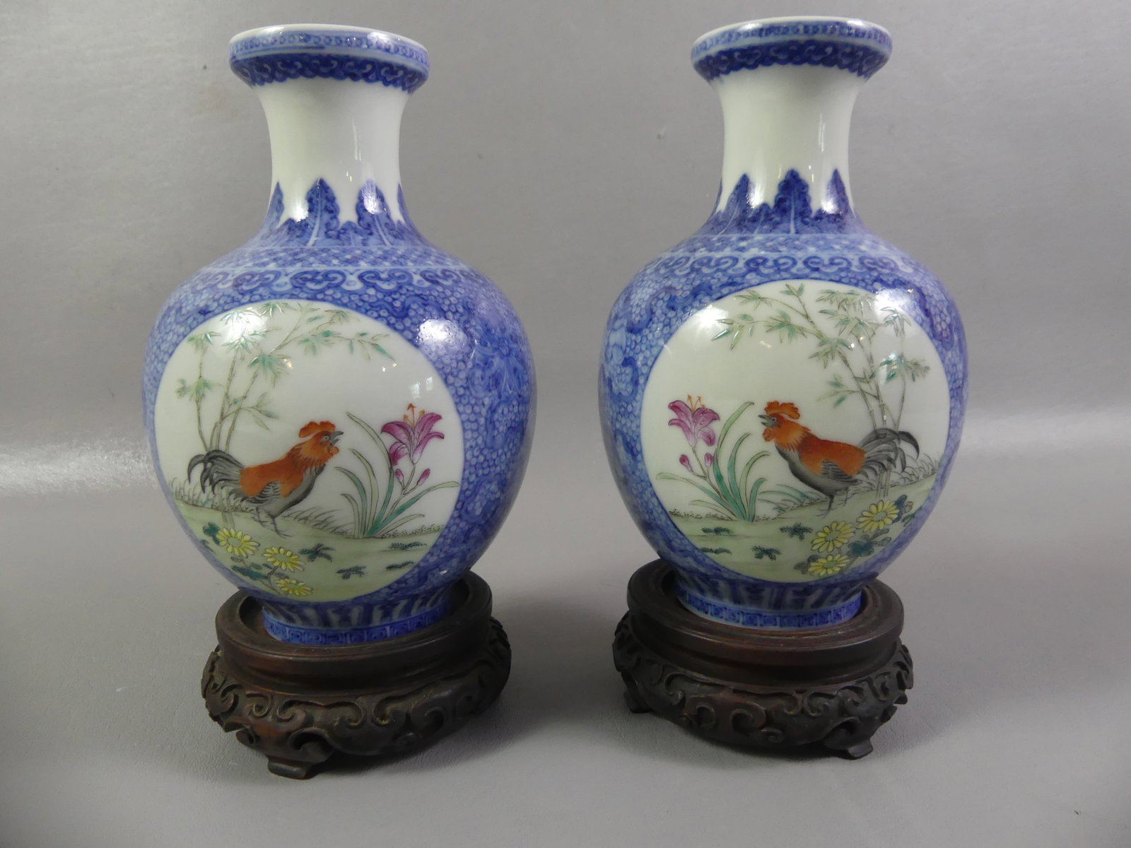 PR QING CHINESE VASES WITH BIRDS: Pair fine antique Chinese porcelain vases in cobalt blue with reserve medallions of rooster and flowers/eagle in landscape. Qing dynasty mark on underside. Both have wood bases. Vases alone are 7 in t