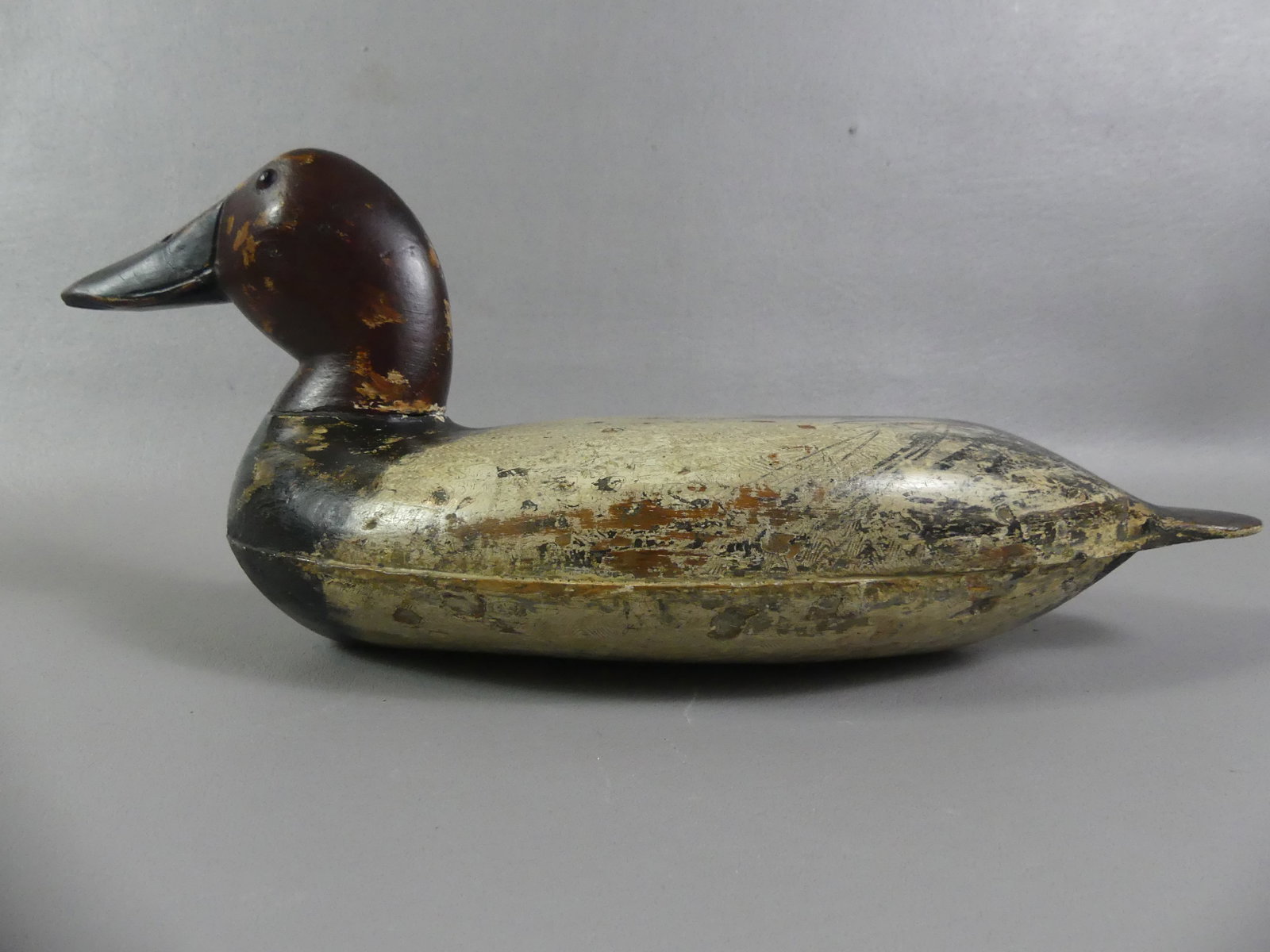 ROBERT ELLISTON OF IL DECOY: Robert Elliston of Illinois carved wood, hollow-body canvasback duck decoy with wavy comb original paint. Some paint loss and touch-up. Size: 16 in long and 6 in high.