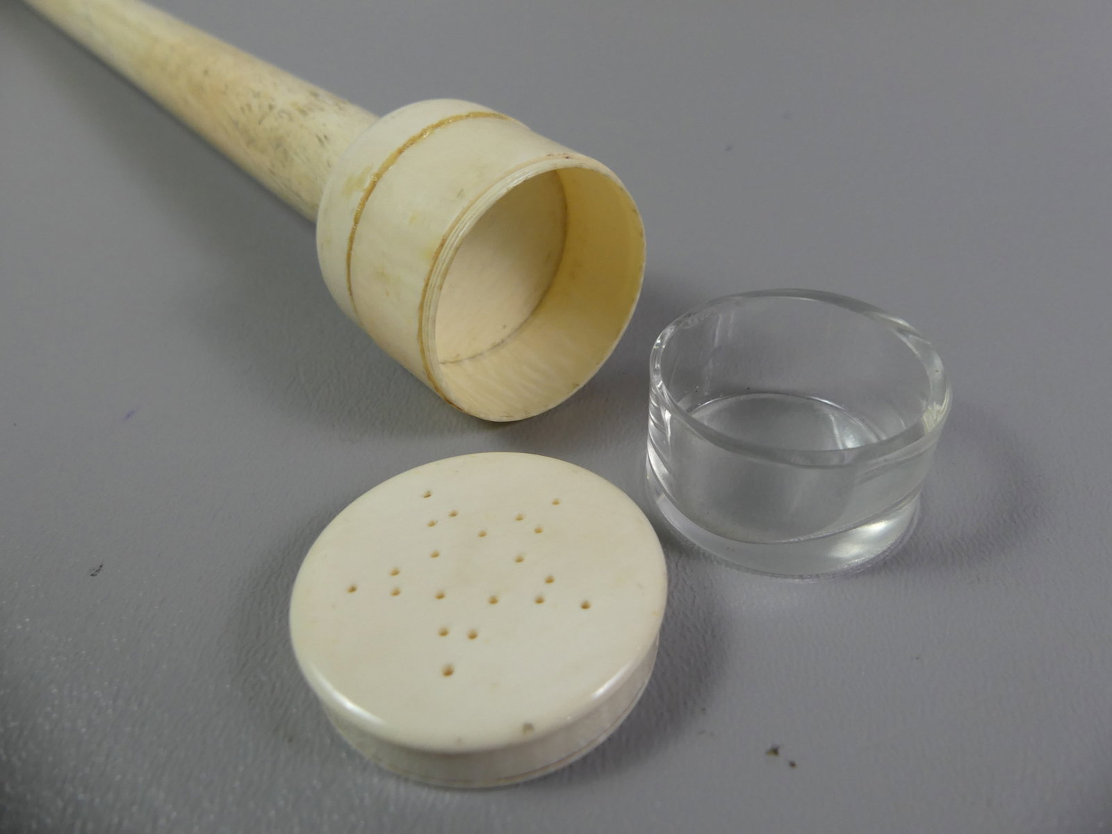 WHALE BONE POMANDER CANE: 19th century sailor made whalebone cane with grip in form of a pomander jar with star-shaped holes and interior glass container. Center of shaft screws off. 31.5 in long and top is 1.5 in diameter. Go
