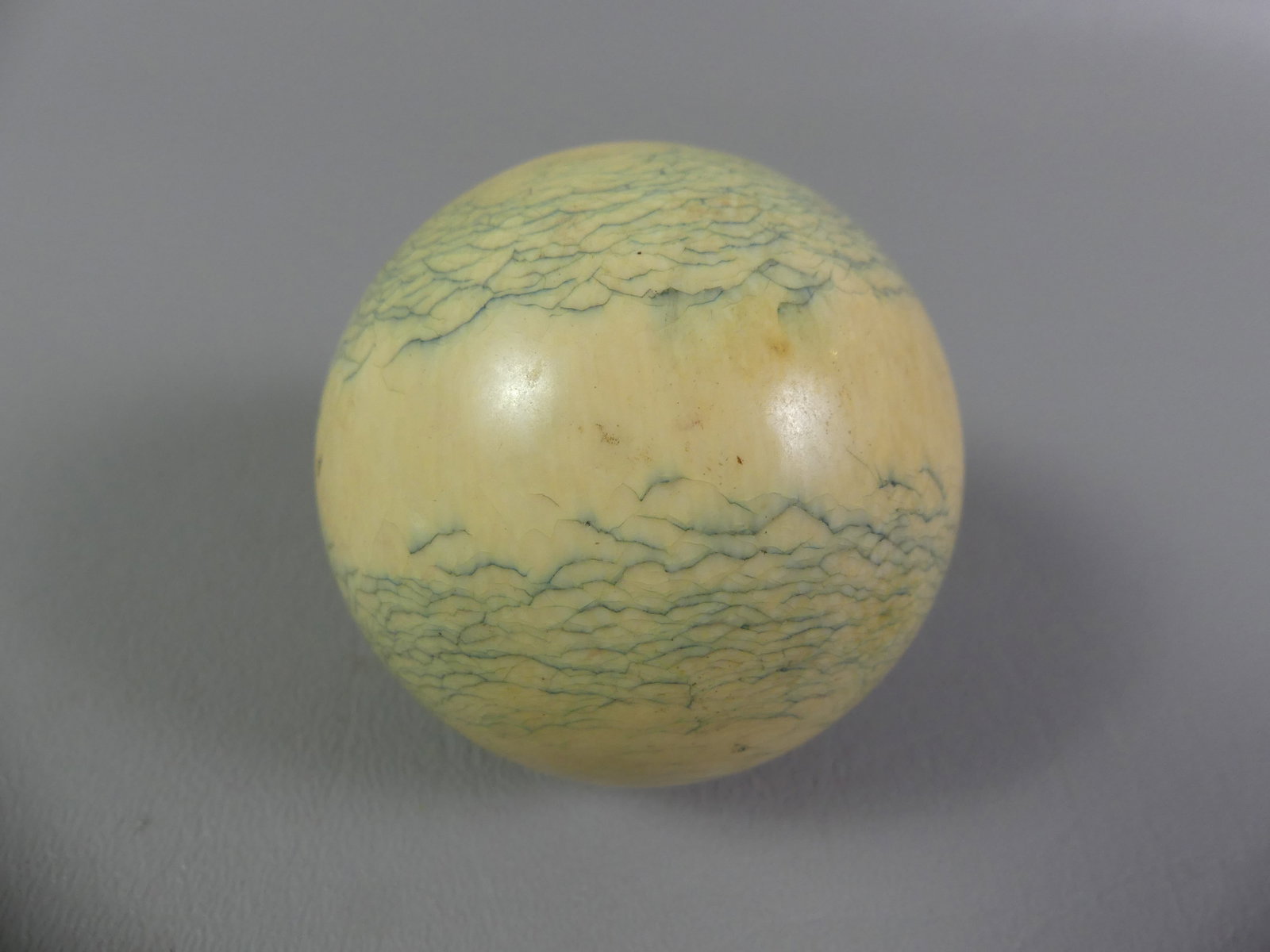 ANTIQUE BONE BILLIARD BALL: 19th century bone billiard ball, 2.25 inch diameter. Has allover agelines.