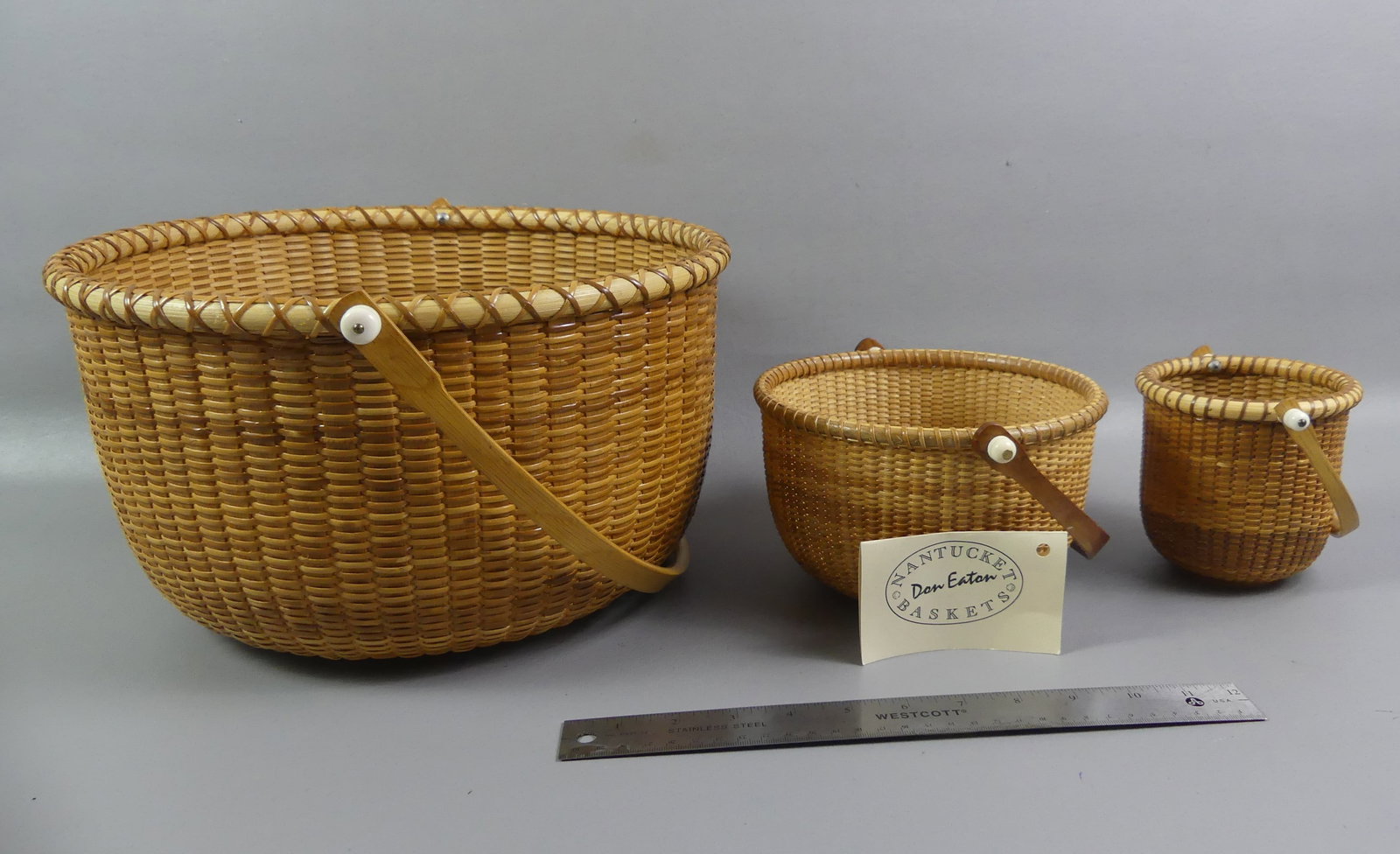 3 NANTUCKET BASKETS: Lot 3 vintage Nantucket baskets - 13.5 x 7.5 inch signed Panam 1998; egg basket 4.5 inch signed Panam 1996; and attributed to Don Eaton with scrimshaw medallion on bottom, 7.5 x 4.5 inches.