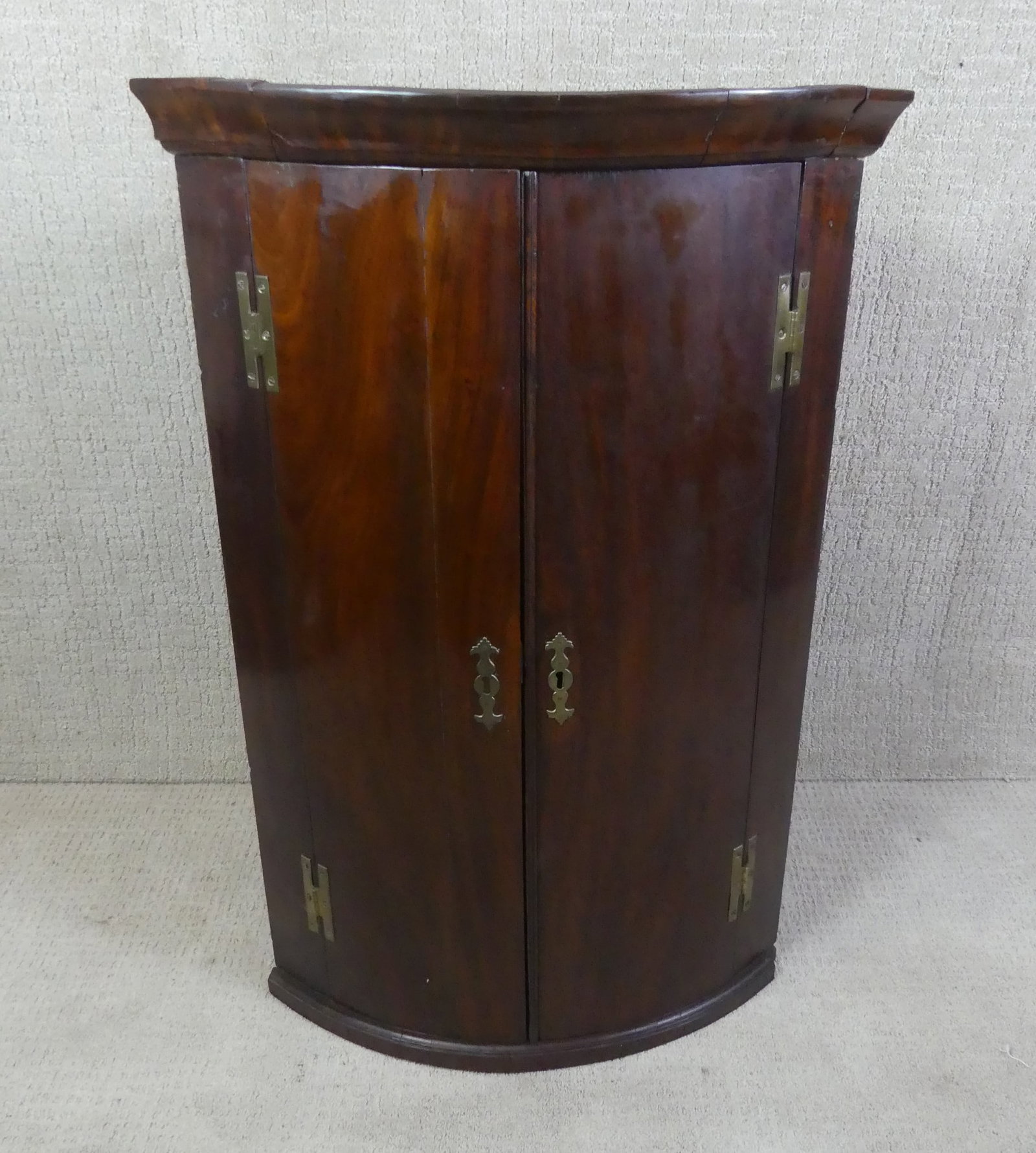 PERIOD MAHOGANY CORNER WALL CABINET: 18th century mahogany curved front, 2 door corner wall cabinet. 42 in high, sides are 18 in deep.