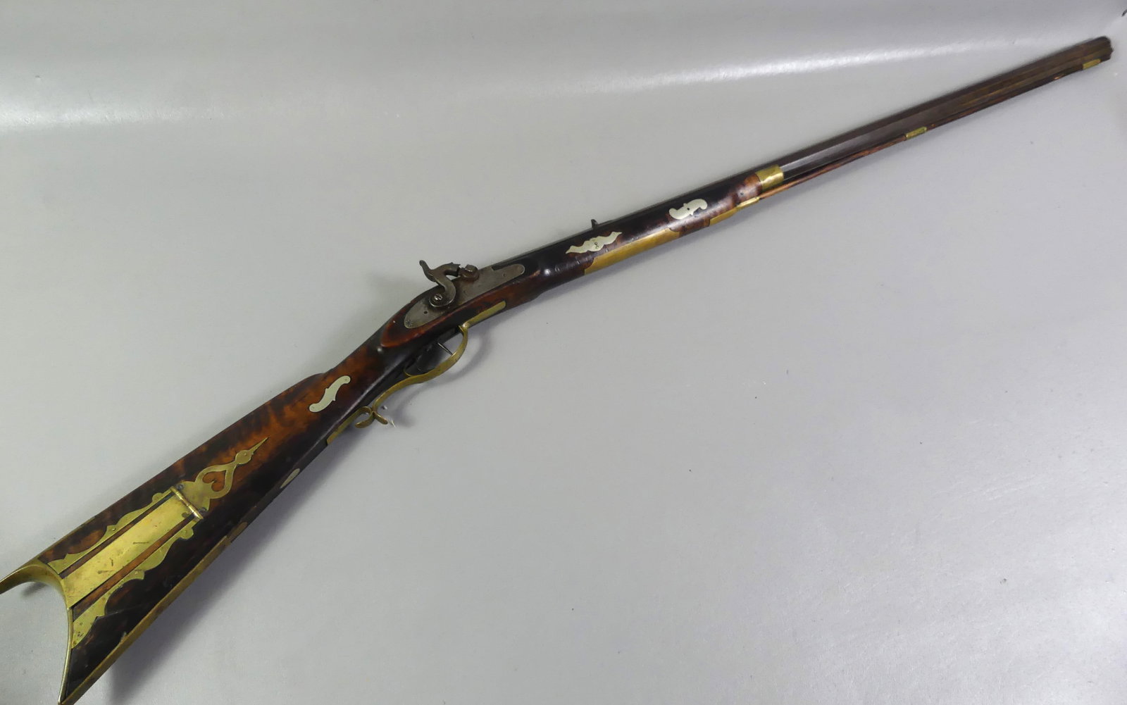 CHARLES RAKER KENTUCKY RIFLE: Antique Kentucky rifle with silver inlay, brass mounts and patch box, octagonal barrel about 38 cal. Has percussion fire, lightly (almost illegible) engraved name Charles Raker (Bedford County PA ca. 