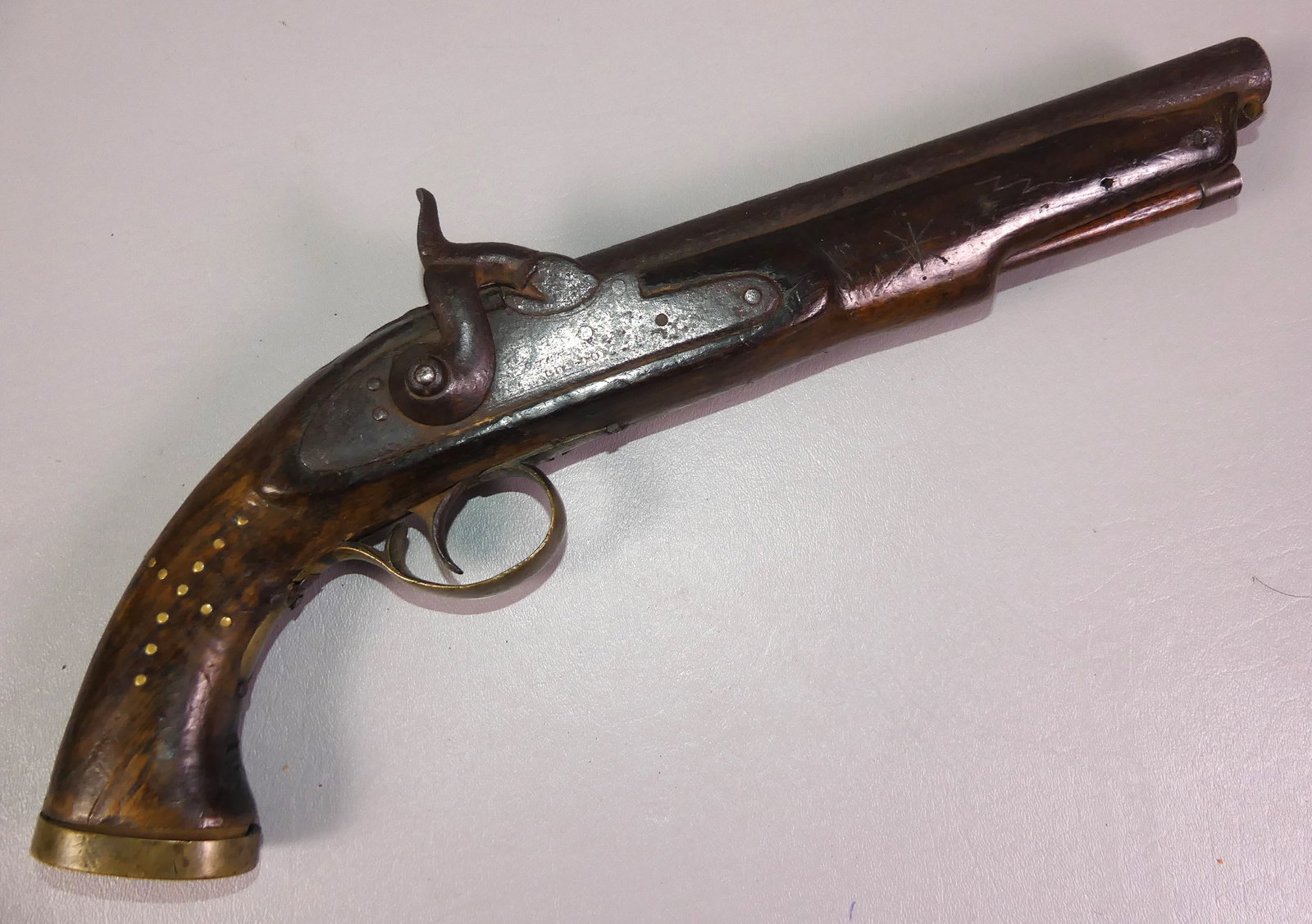ANTIQUE ENGLISH PISTOL: Antique English percussion fire pistol stamped LONDON with illegible hallmarks. Has brass mounts and studs, about 70 caliber. 15.5 in long.