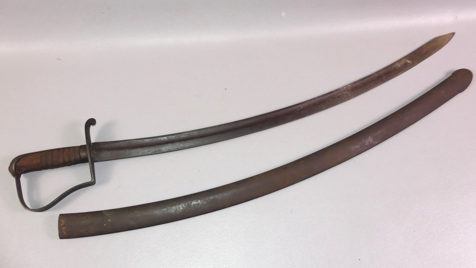 WAR OF 1812 CAVALRY SWORD - STARR: Scarce War of 1812 cavalry saber with wood grip and steel scabbard. Stamped on blade US HP/ET N. STARR (maker Nathan Starr). Curved 32 in blade, 37 in overall.