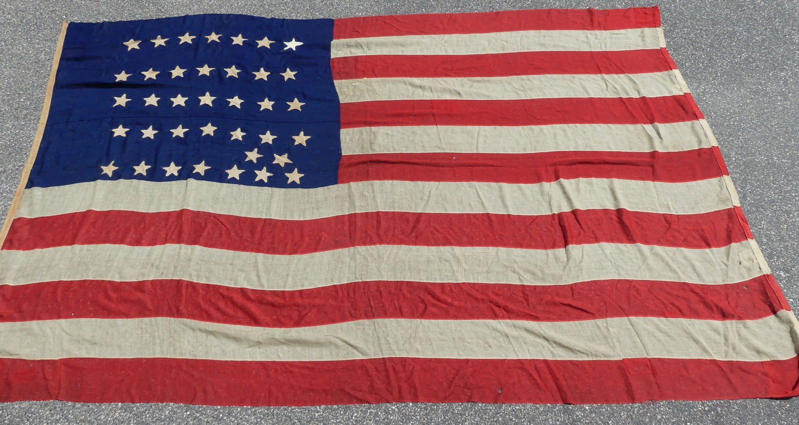 12 FT CIVIL WAR FLAG: Large Civil War era American hand-stitched linen flag with total of 36 stars (it appears it was originally 34 but 2 were added later). One star has been replaced. 12 ft 5 in by 8 ft 6 inches. Several