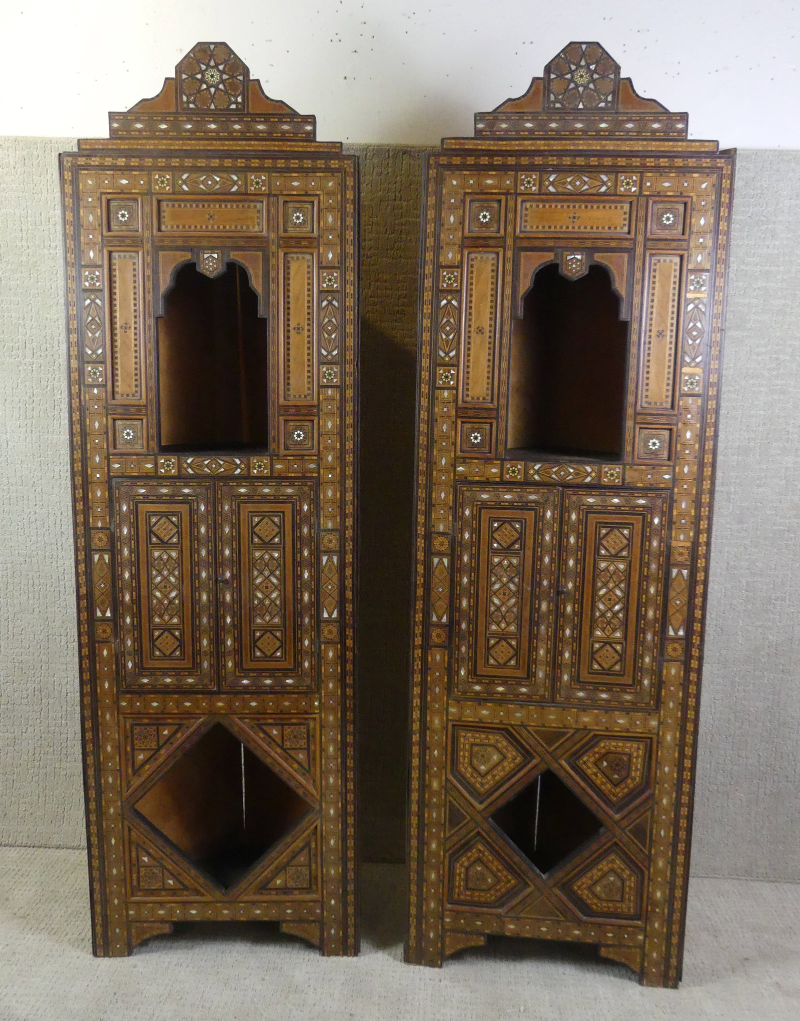 PAIR INLAID MOROCCAN CORNER CABINETS: Pair of small, highly inlaid Moroccan corner cabinets with 2 doors and 2 open compartments. 75 in tall x 23 in w x 17 in deep. VG condition.