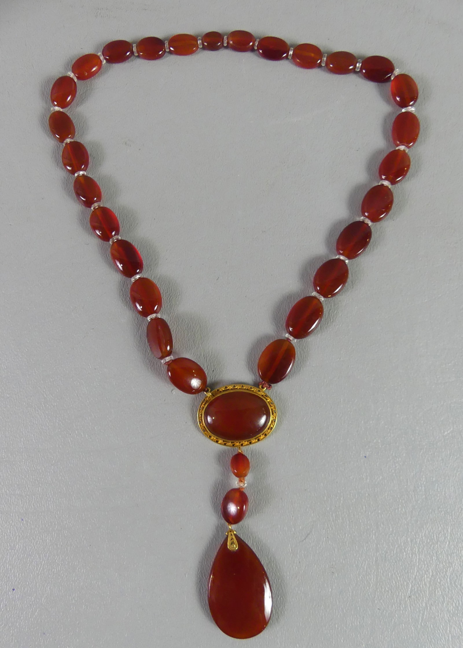 18K GOLD & CARNELIAN NECKLACE: Fine polished carnelian gemstone necklace with pendant and gold mounts stamped 18k. In Tiffany & Co padded box. Necklace is 16 in long plus 3.5 in drop, teardrop pendant is 1.25 in long.