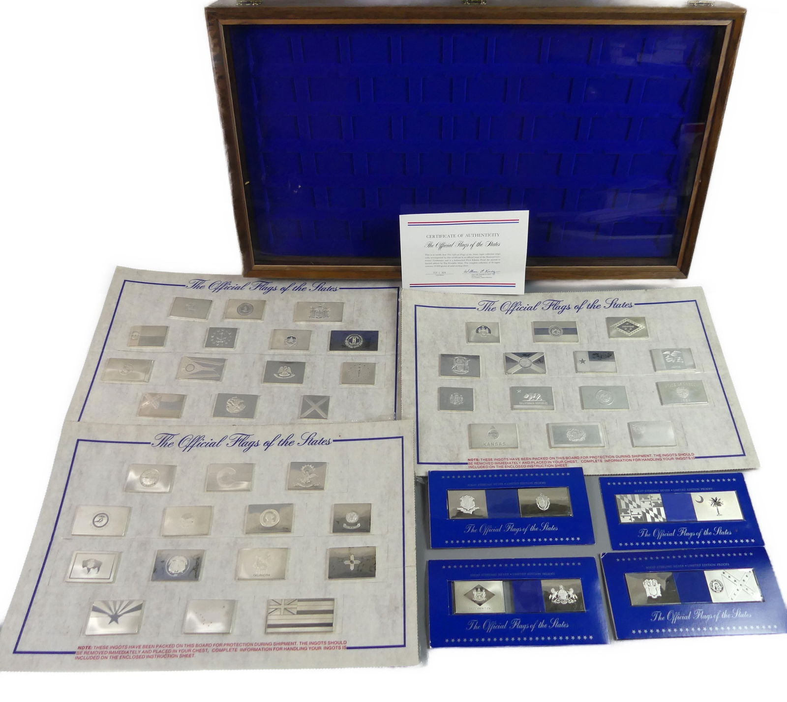 50 STATE FLAGS SILVER MEDALLIONS & CASE: Lot of 50 Franklin Mint American State Flag ingots from 1974, First Edition Proof Set, in .925 sterling silver. Comes with a nice walnut display case, 26.5 x 15 inches. Ingots have never been opened.