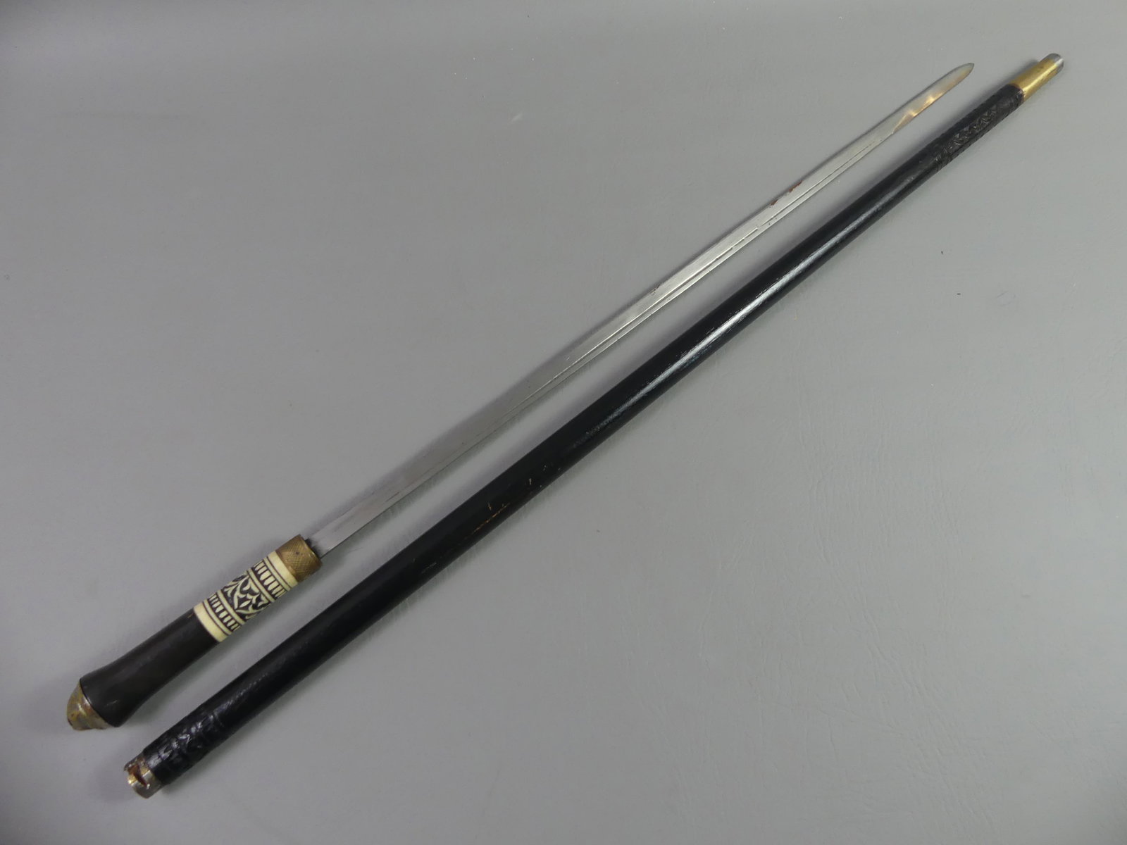 OLD SWORD CANE - CARVED BONE HANDLE: Old Asian sword cane with wood shaft, carved bone and brass. 36 in long, blade is 23.5 in.