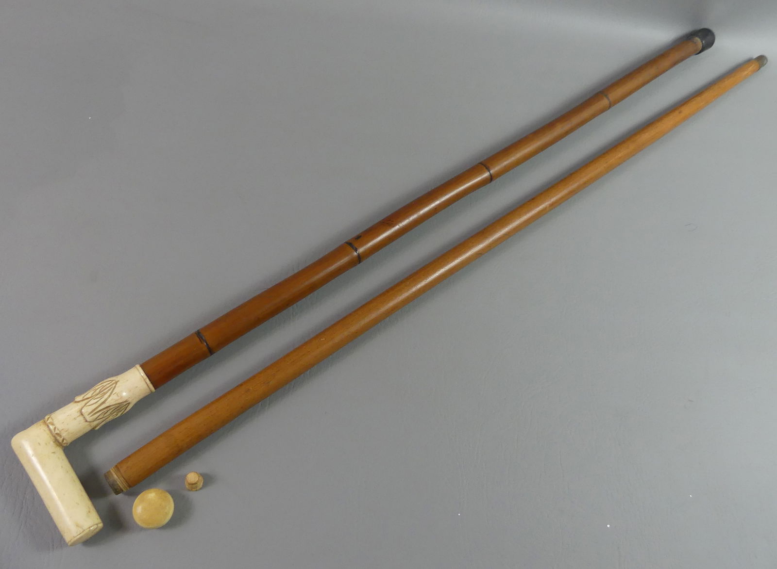 2 OLD CANES: FLASK & CARVED BONE: Lot 2 old canes: flask cane with screw-off bone knob and glass vial having wooden shaft, 36.5 in long; and a carved bone and bamboo cane, 35.5 in long.