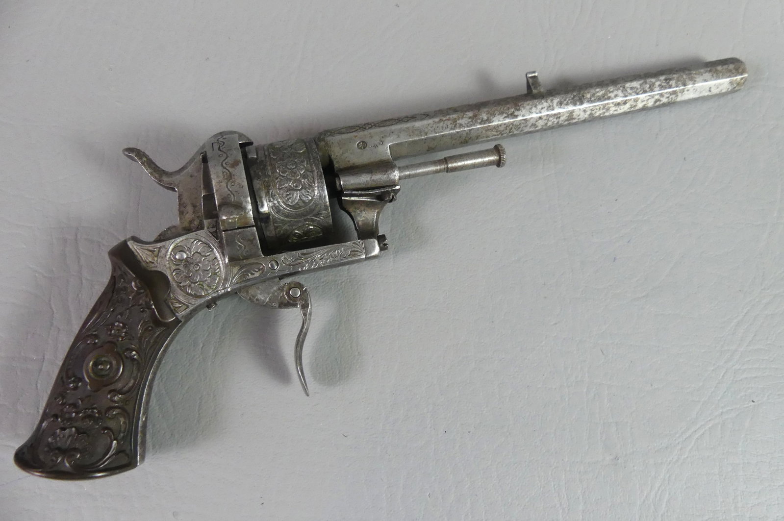 FRENCH PINFIRE REVOLVER - REPOUSSE GRIPS: 19th century French pinfire revolver with repousse carved grips and engraved designs. Has crowned W hallmark and serial number 11031. 10 in long, octagonal barrel 5.75 in. About 25 caliber. Good mecha
