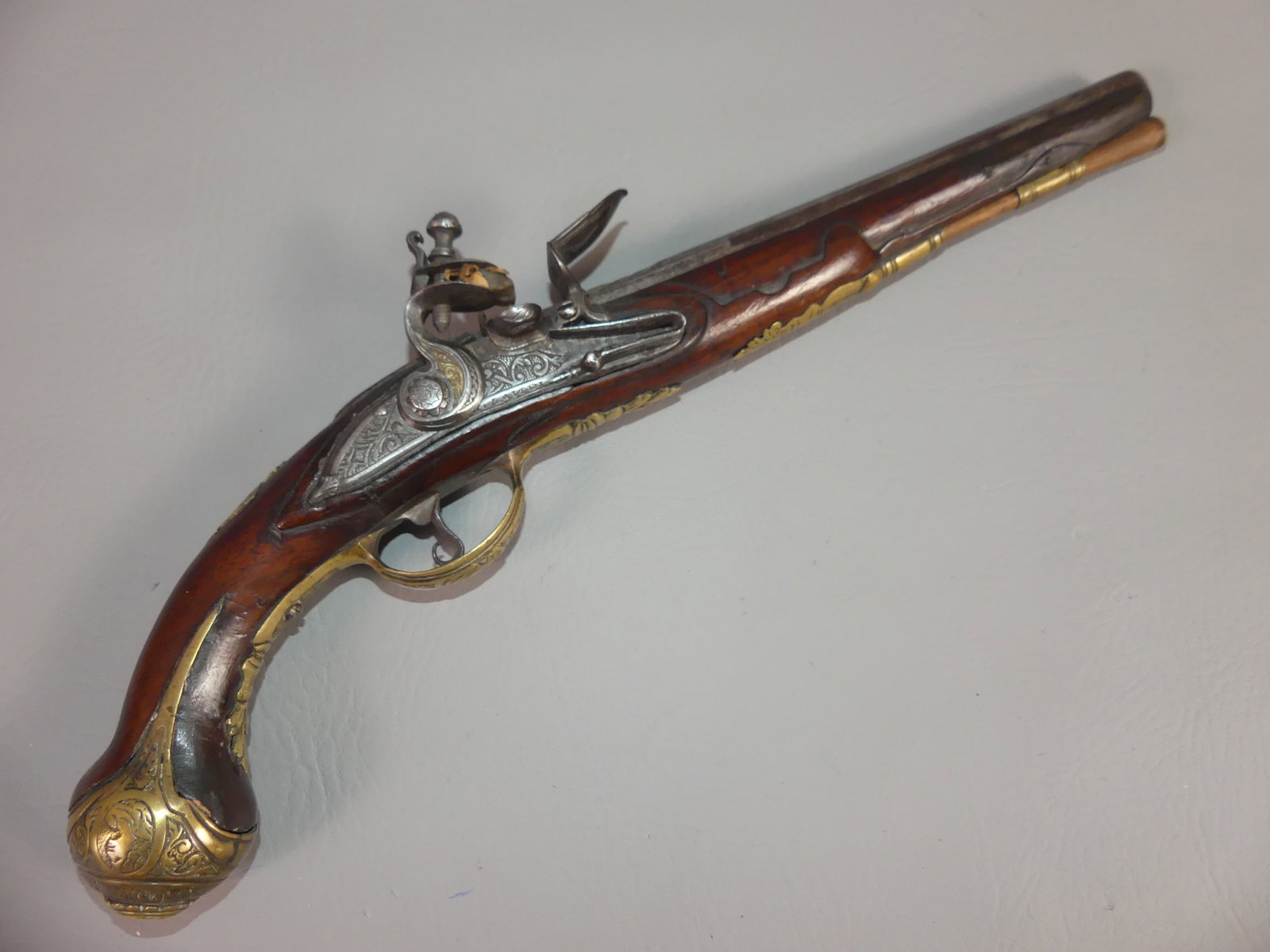ITALIAN MILITARY FLINTLOCK PISTOL - LANDI: Circa 1700 Italian military flintlock pistol with 7 busts of women engraved on brass mounts. Made by Landi (not signed). 15.5 in long, barrel 9.5 in, about 50 caliber. Good mechanics.