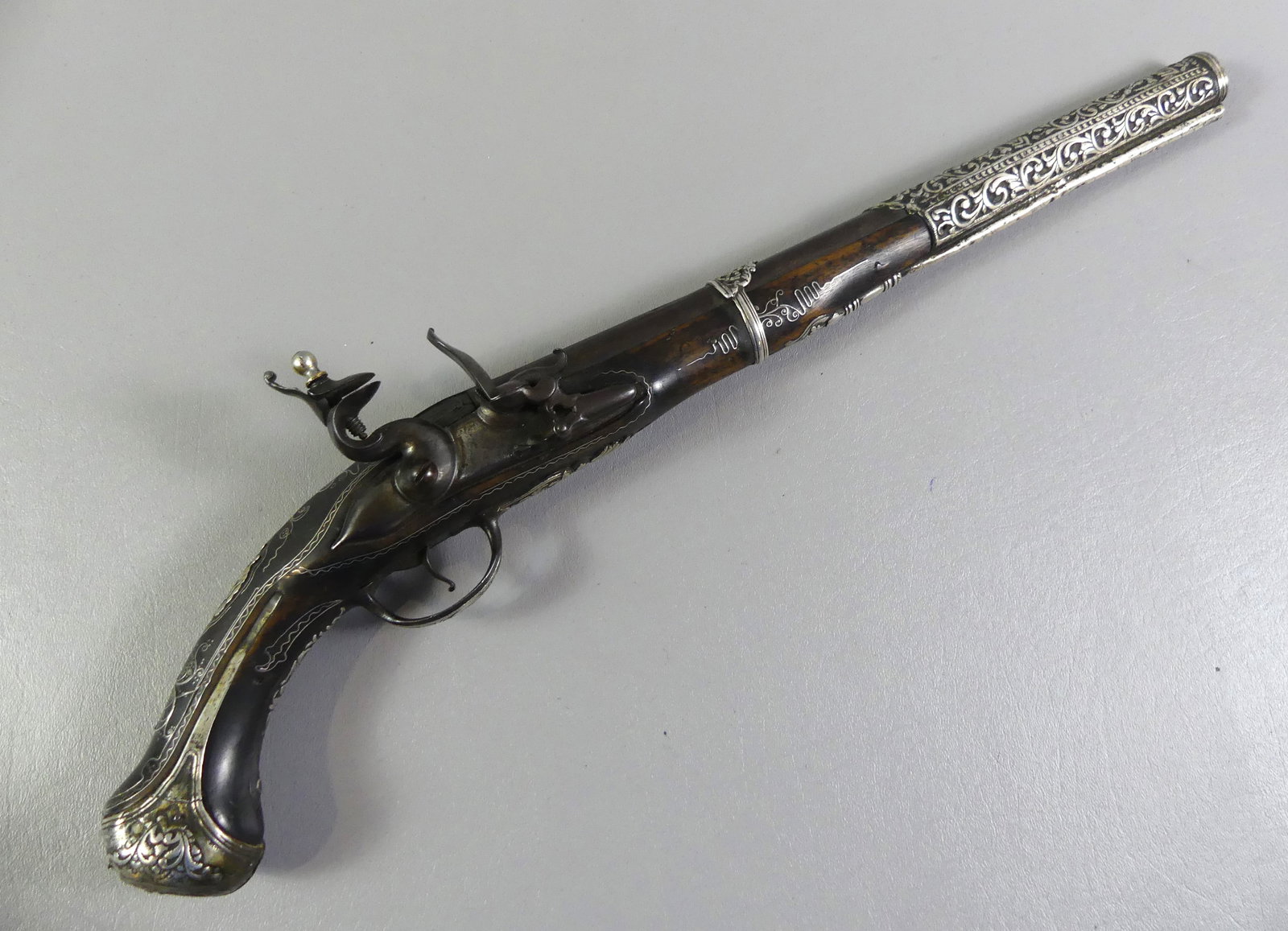 TURKISH FLINTLOCK PISTOL - SILVER INLAY: Fine and elaborate silver overlaid Turkish flintlock pistol circa early 1800's. Hallmark on barrel, 21 in long about 60 caliber. Has some damage to end of grip.