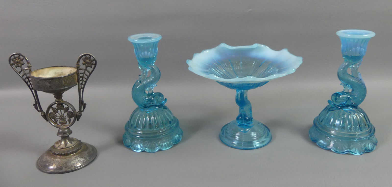 NORTHWOOD BLUE OPAL COMPOTE & CANDLESTICKS: Antique set of 3 matching Northwood blue opal compote and candlesticks with dolphin bases. Plus a metal Victorian stand by J. Tufts 1188 (2.25 in fitter). 5 in compote, 6.5 in sticks. VG condition.