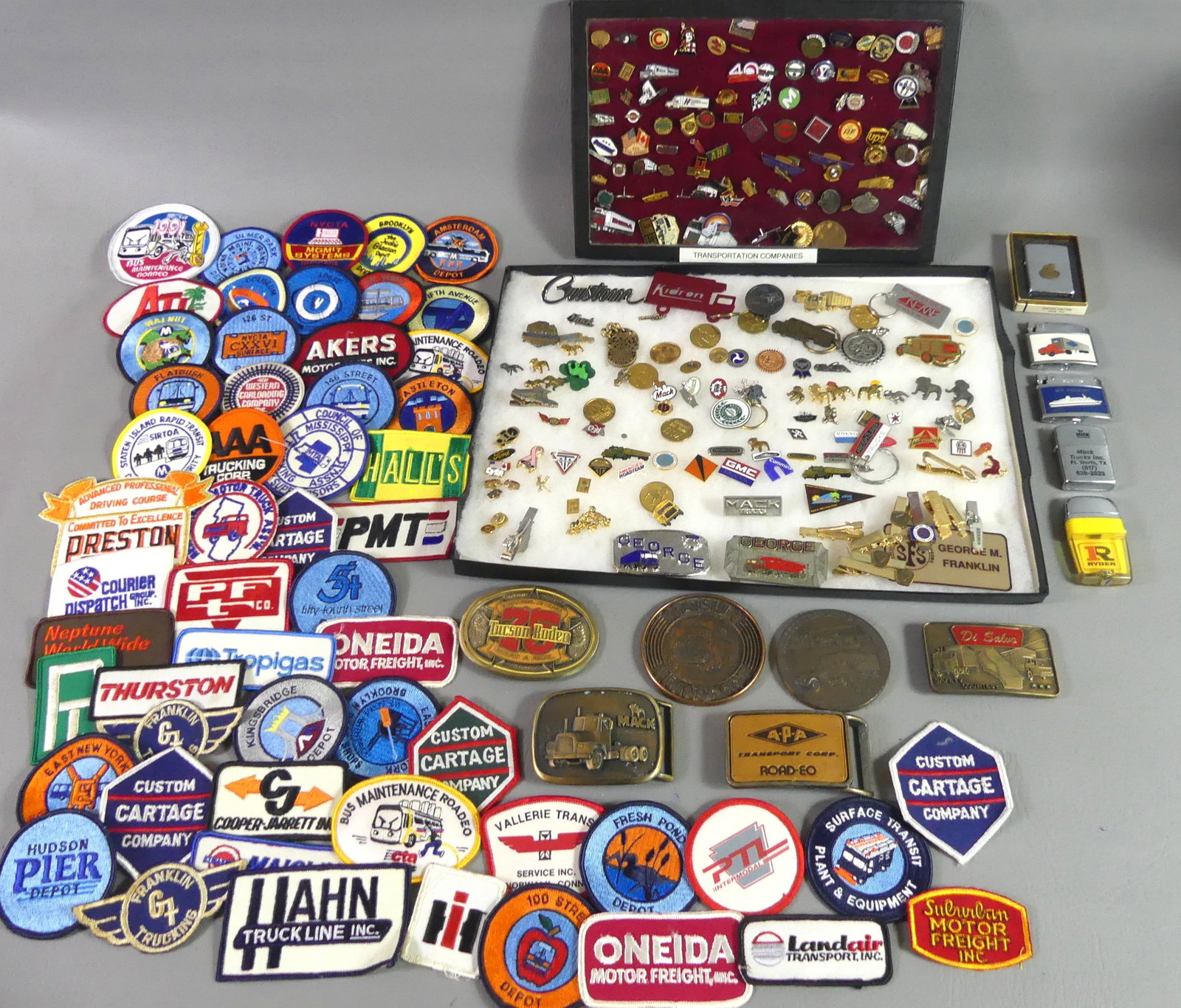 TRANSPORTATION PINS, BUCKLES, PATCHES, LIGHTERS: Large lot of transportation related items including about 55 fabric patches; many pins; 5 lighters; 6 belt buckles; and a size large red jacket covered with transportation patches.