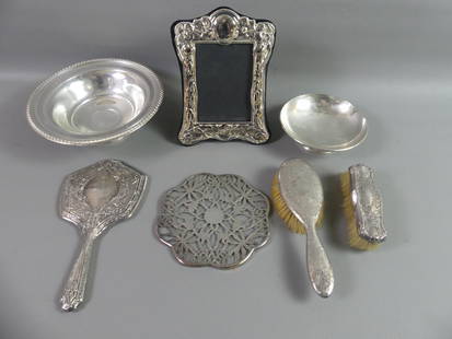 7 PCS WEIGHTED STERLING SILVER: Lot of weighted sterling silver: 9 in tall fancy picture frame; 2 bowls to 9 in wide; 2 brushes; hand mirror; 7 in glass and silver overlay trivet.