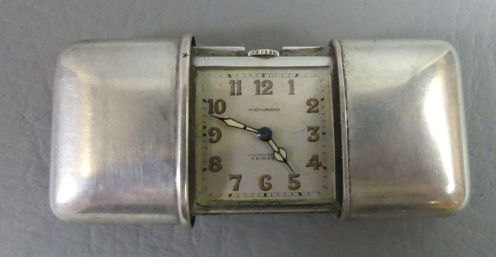 MOVADO SILVER TRAVEL WATCH: Small Movado travel clock in sterling silver slide-open case (stamped 935). Dial signed Movado, Chronometre Ermeto. Serial number 1190795. 2.75 in open, 1.5 x 1.85 in closed. Working. 43.6 dwt.