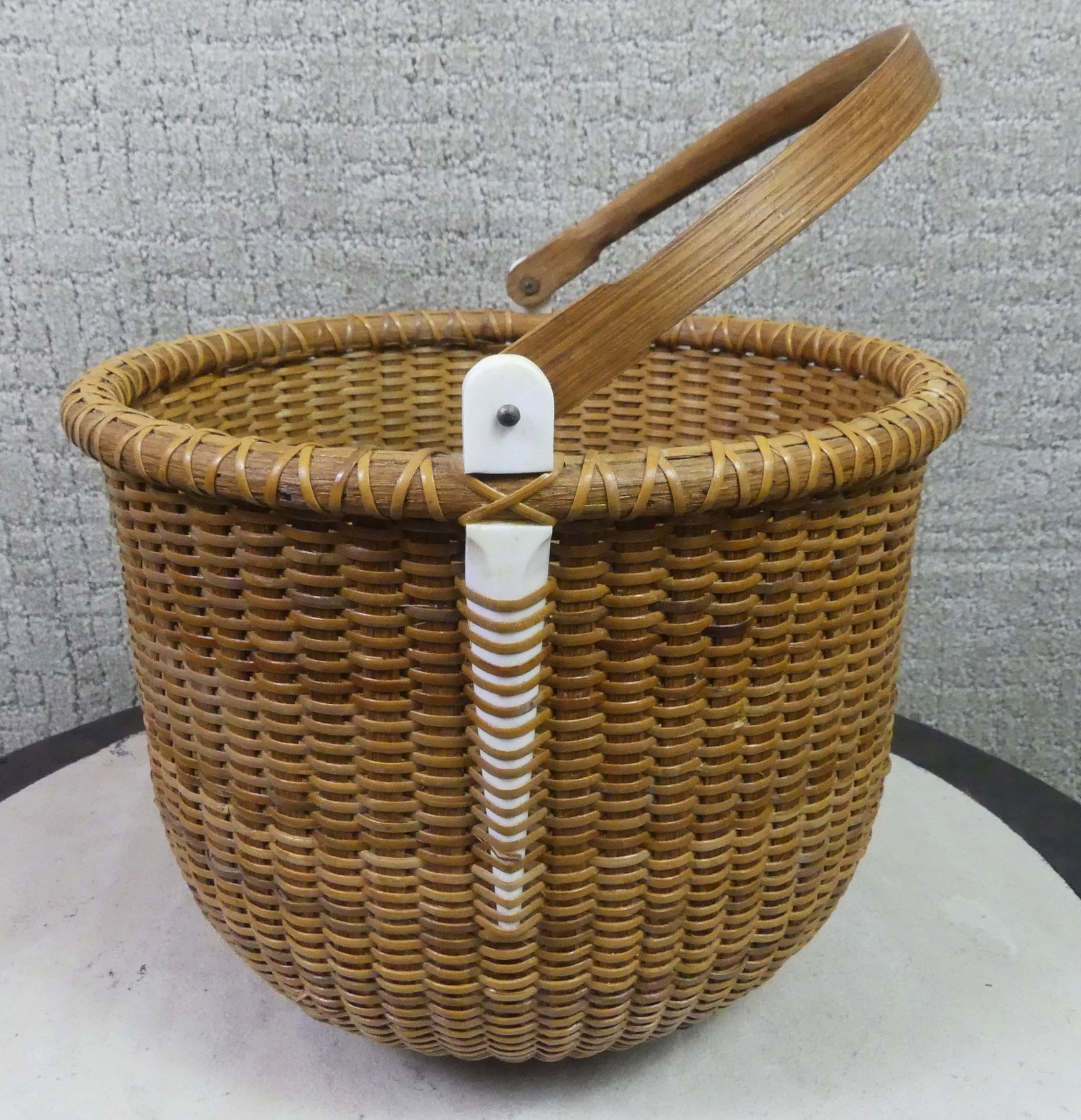 VINTAGE 1977 NANTUCKET BASKET - SIGNED: Old Nantucket swing-handled basket with bone staves, 10 in wide by 8 in high. Dated 1977 and signed indistinctly on underside.