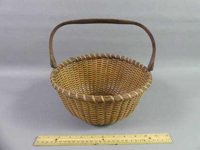 ANTIQUE NANTUCKET BASKET: Antique Nantucket swing-handled basket with wood base, 10 in diam by 6 in high. Unsigned.