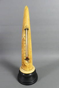 WALRUS TUSK THERMOMETER: Antique walrus tusk mounted with thermometer on ebony stand. 14 in overall, 11 in tusk. Toning/age lines. Working