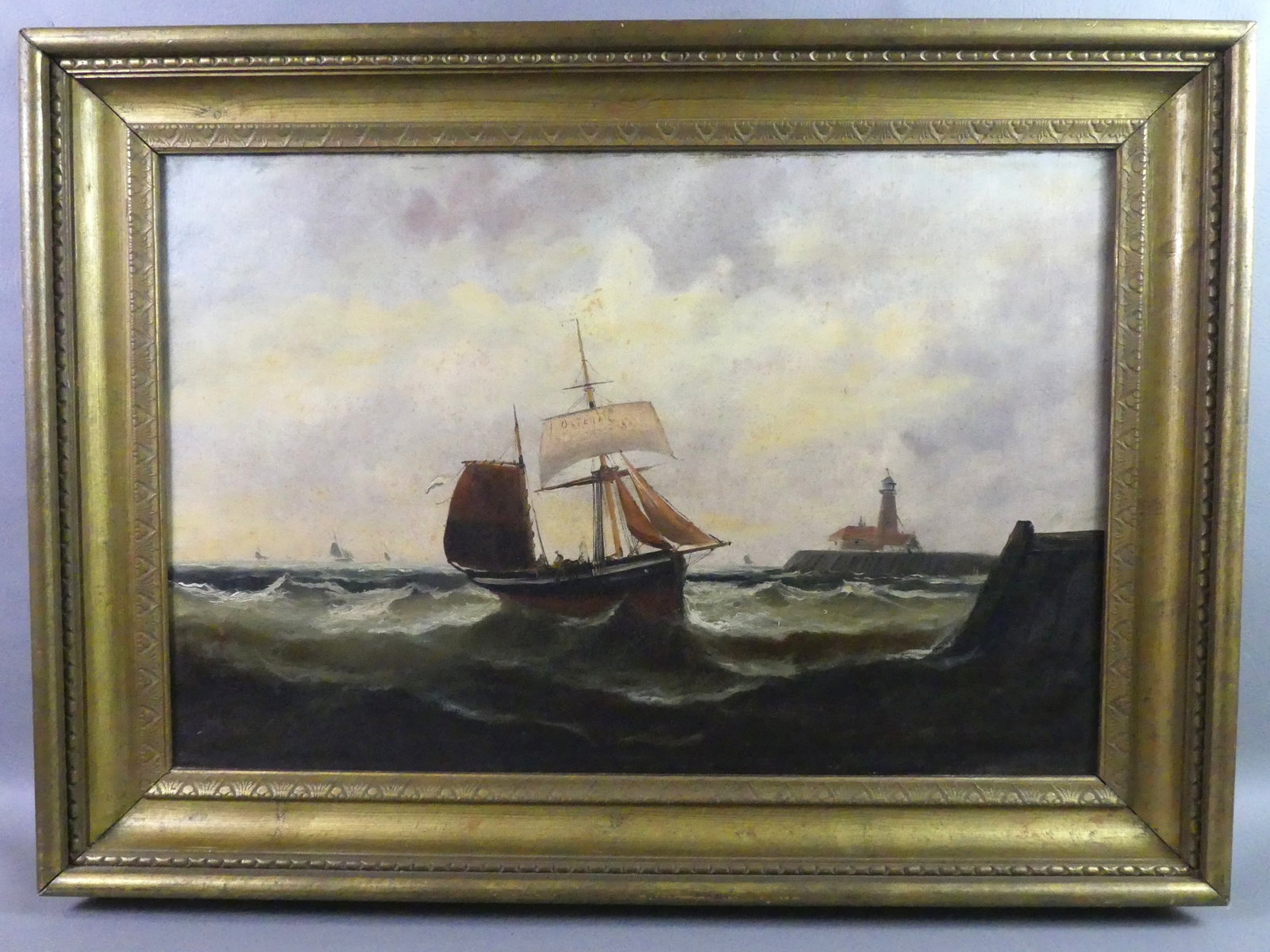 MARINE PAINTING - SAILBOAT & LIGHTHOUSE: Antique continental oil on canvas of a marine scene with sailboat OSTENDE 50 and lighthouse. Indistinctly signed in lower left. 20 x 30 in, framed 27 x 37 in. Light foxing.
