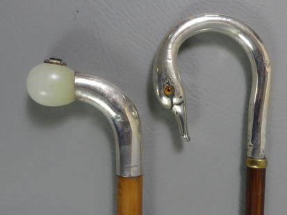 2 STERLING CANES - ONE SWAN: Lot 2 sterling silver handled canes: Shepherd hook style in form of a swan head with English sterling hallmarks, glass eyes, and wood shaft, 35.5 in long; and 4 in sterling and quartz with inset