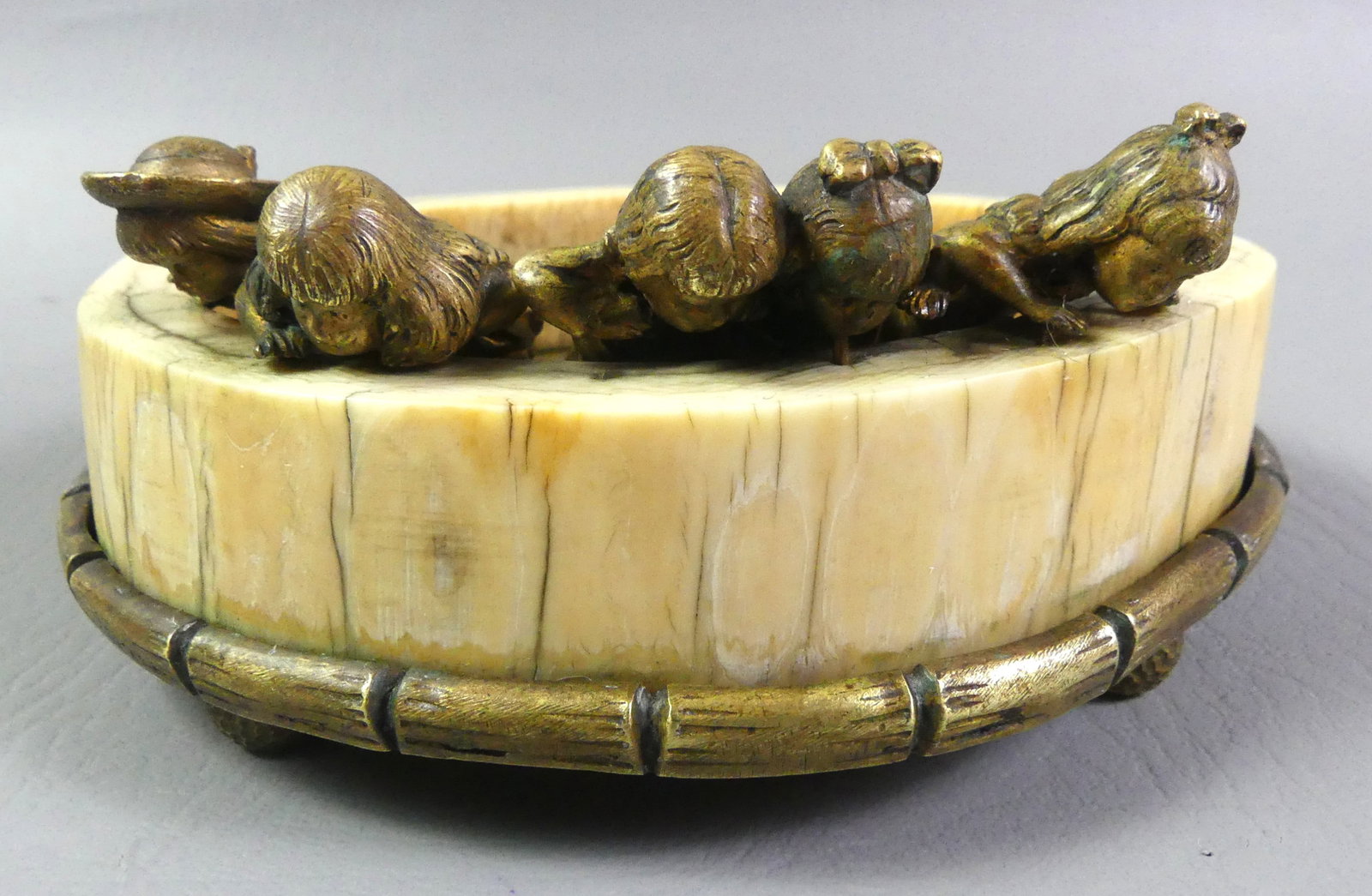 ANTIQUE BRONZE & BONE BOWL: Unusual antique gilt bronze and carved bone small bowl or ashtray with 5 children looking over a wall. Attributed Austrian circa 1900. Unsigned. 5.5 in wide by 2.5 in high.