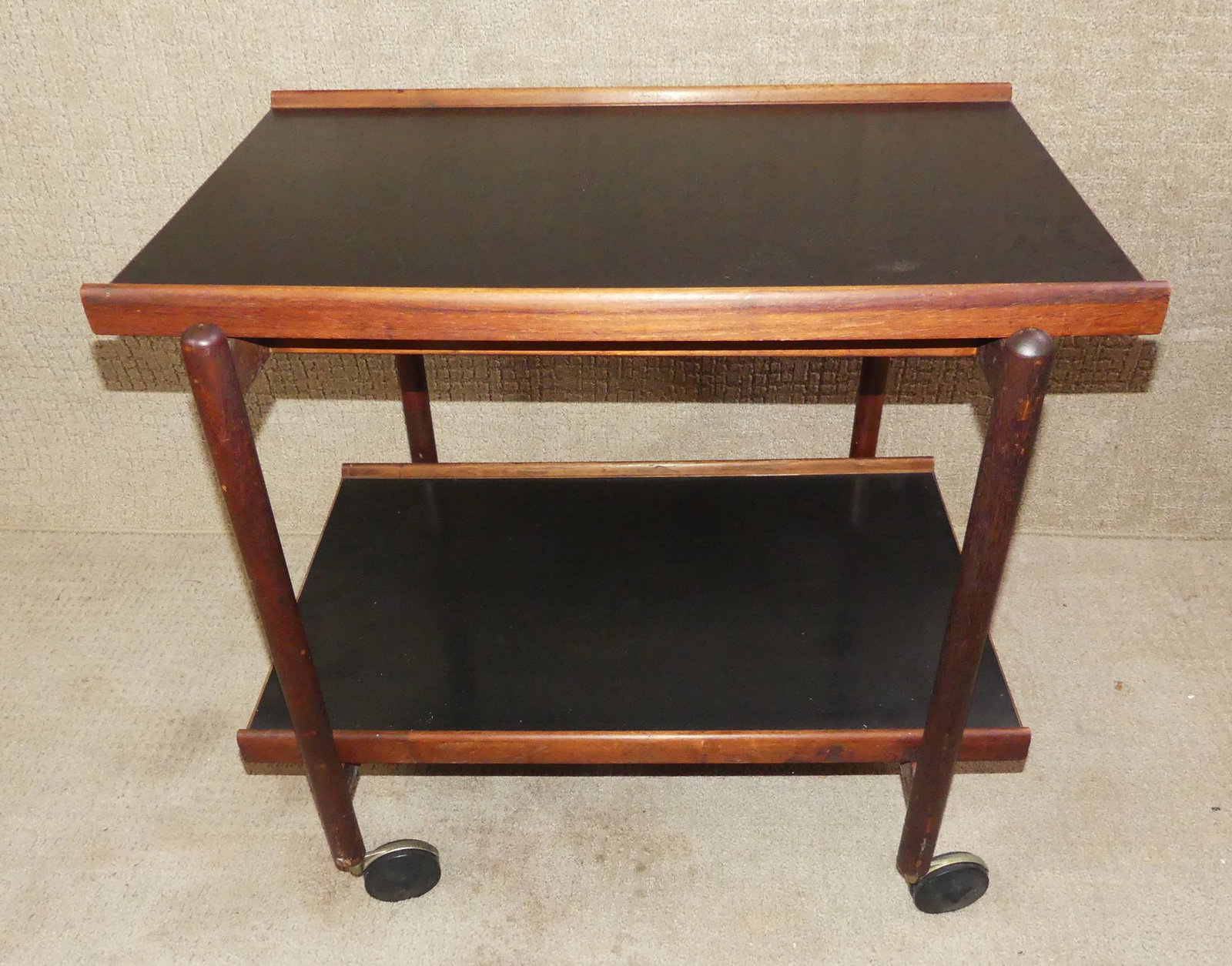 DANISH MODERN TEAK CART: Mid century modern Danish teakwood 2 shelf rolling cart with black laminate tops. Unsigned. 28 in w x 26 h x 17 d.
