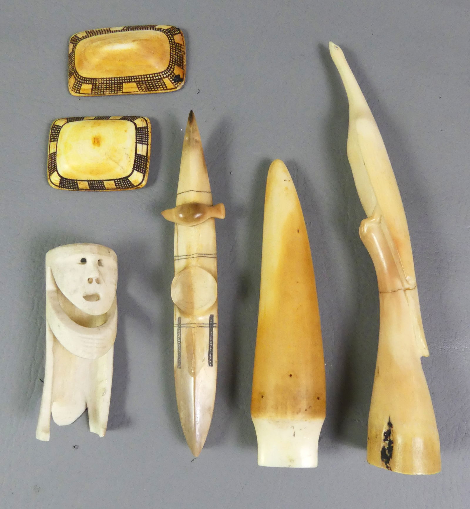6 INUIT CARVED BONE ITEMS: Group of 6 Inuit carved bone items: Signed Paul Nattancuk kayak with seal (missing Eskimo); 9 in bird (repair); 6 in spear tip; 7 in figure; and 2 carved bone belt or necklace pieces to 2.75 in.