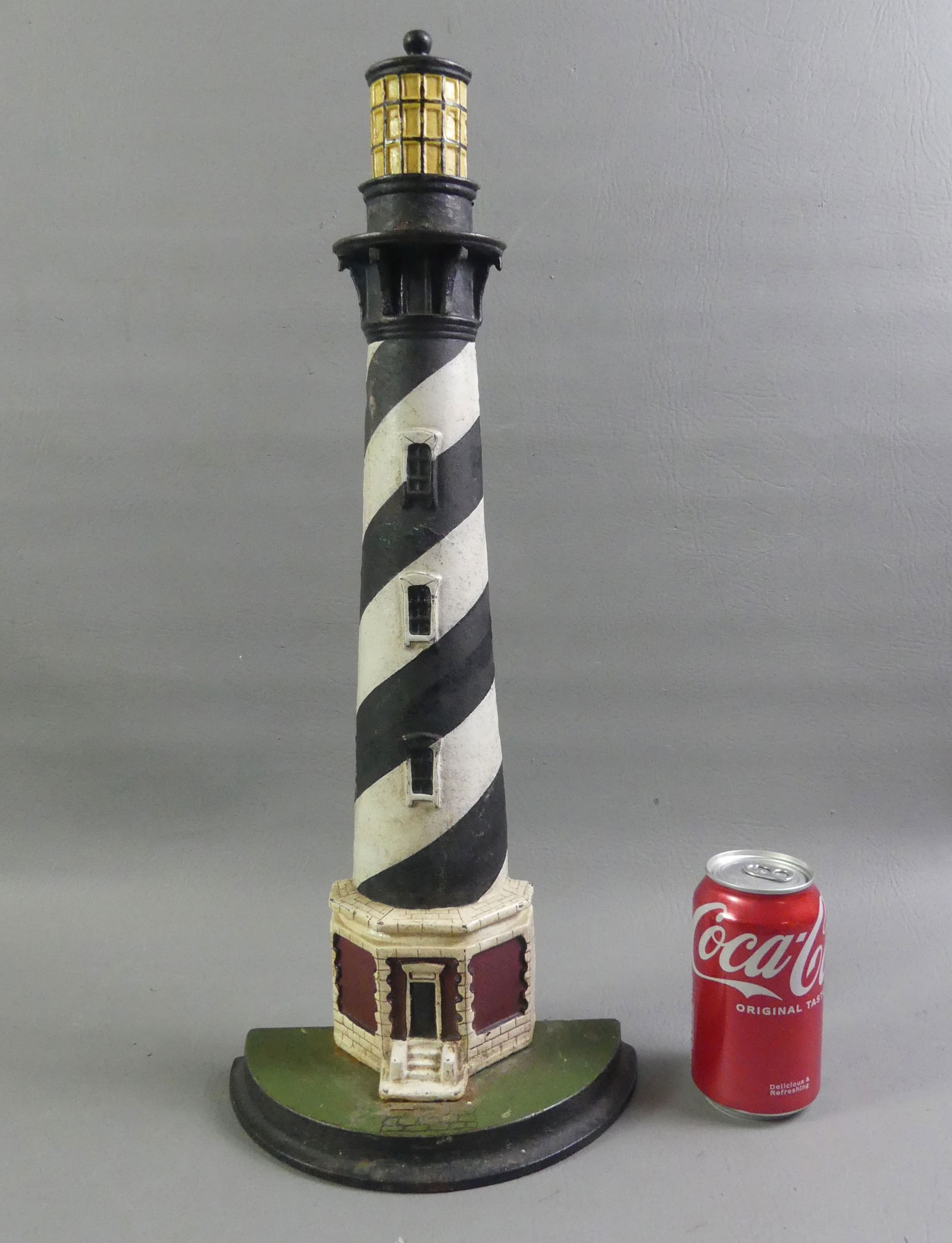OLD IRON LIGHTHOUSE DOORSTOP: Cape Hatteras painted iron lighthouse doorstop, circa 1920-1930, American. This hollow half round casting is from an unknown foundry. On attached molded plinth. Note: Cape Hatteras light represents th