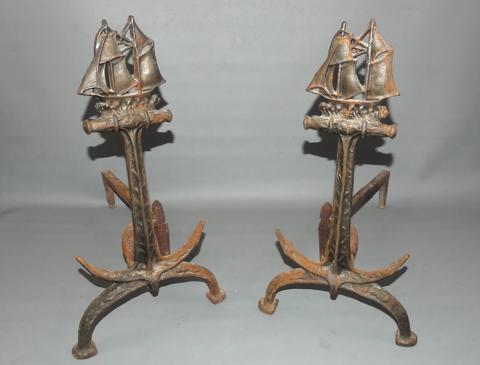 PAIR OLD ANDIRONS WITH SHIP: Pair of old iron nautical-themed andirons with sailboat topper. 18 in high x 10 w x 19 deep.