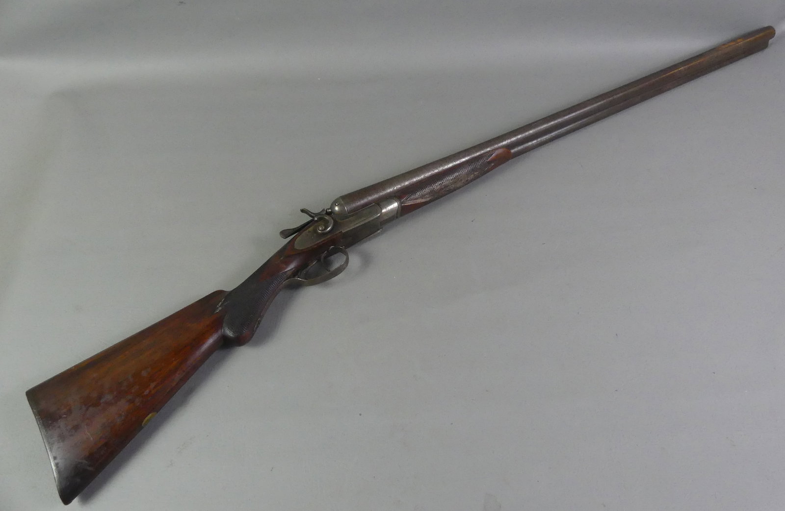 PARKER ANTIQUE SHOTGUN 12 GAUGE: Antique double-barrel 12 gauge percussion shotgun signed Thomas Parker. Has 30 in damascus barrels stamped Fine Laminated Steel. Has checkered walnut stock and hunt scene on plastic butt plate. May be