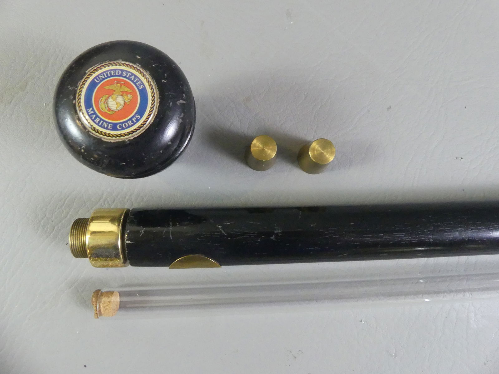 US MARINE CORPS FLASK CANE: Old ebony cane with internal 14 in long glass flask and 2 small brass shot cups. Top has insignia of US Marine Corps. Monogram on brass disk.