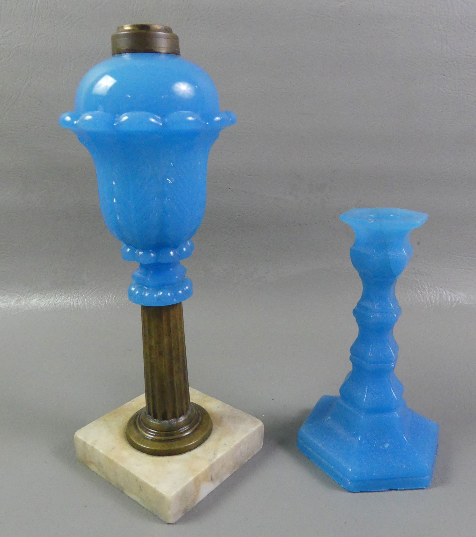 SANDWICH BLUE WHALE OIL LAMP & CANDLESTICK: Lot 2 pieces of starch blue colored Sandwich Glass: 11 in whale oil lamp with Acanthus pattern font and brass and marble base; together with a blue 7 in candlestick with 1.5 inch U shaped glue repair