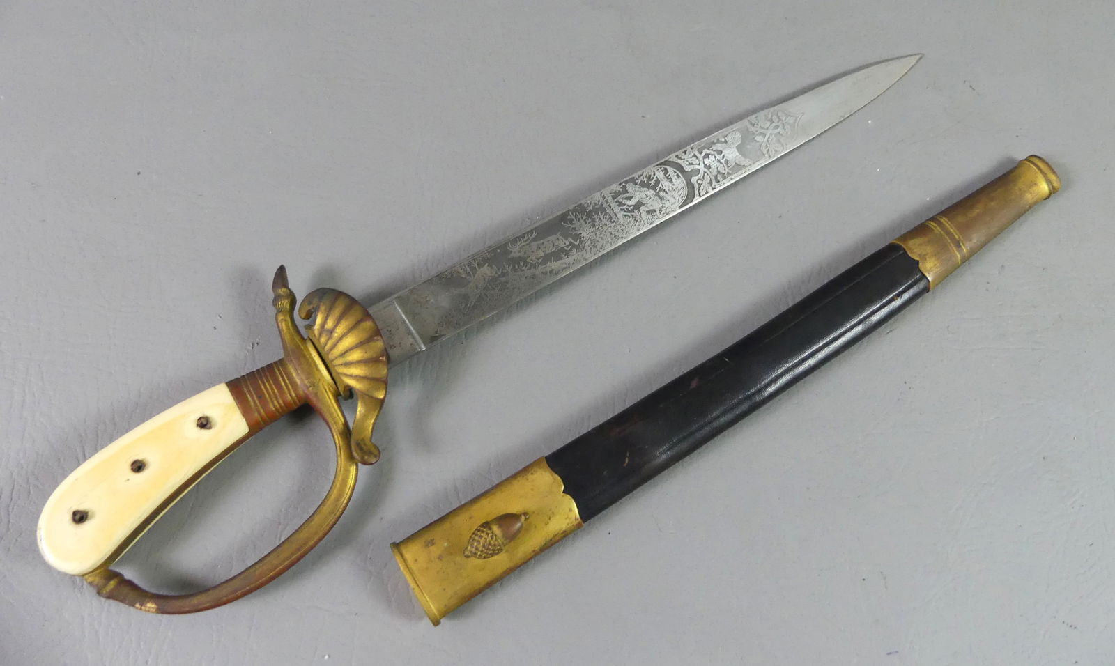 ANTIQUE EICHORN GERMAN HUNT DAGGER: Circa 1930's German hunting dagger signed Carl Eickhorn with nicely engraved steel blade with hunting scenes. Has carved bone handle with acorn studs (4 missing). 18 in long, 13 in blade. Has leather